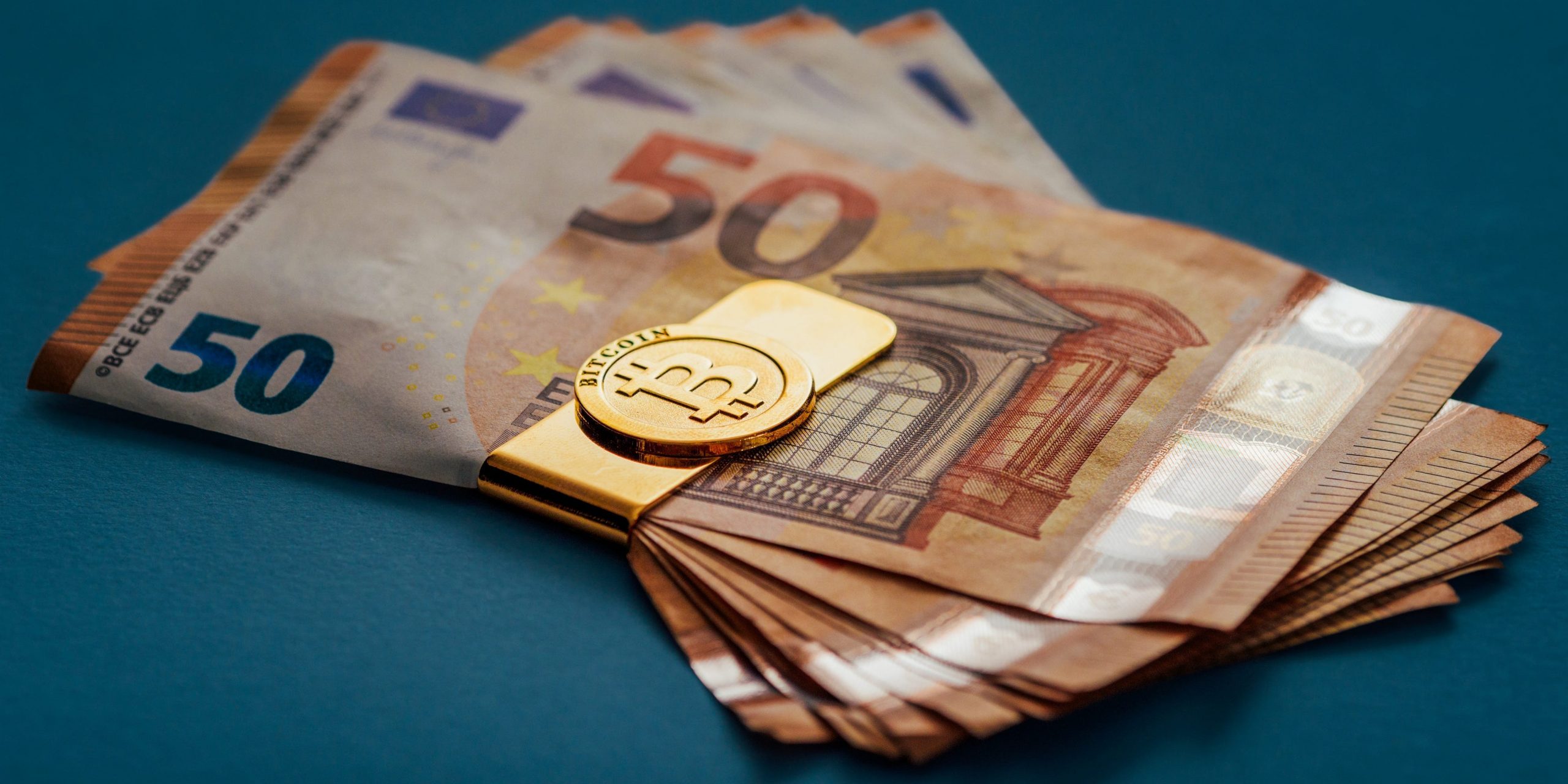 Euros wrapped in a gold bitcoin money clip