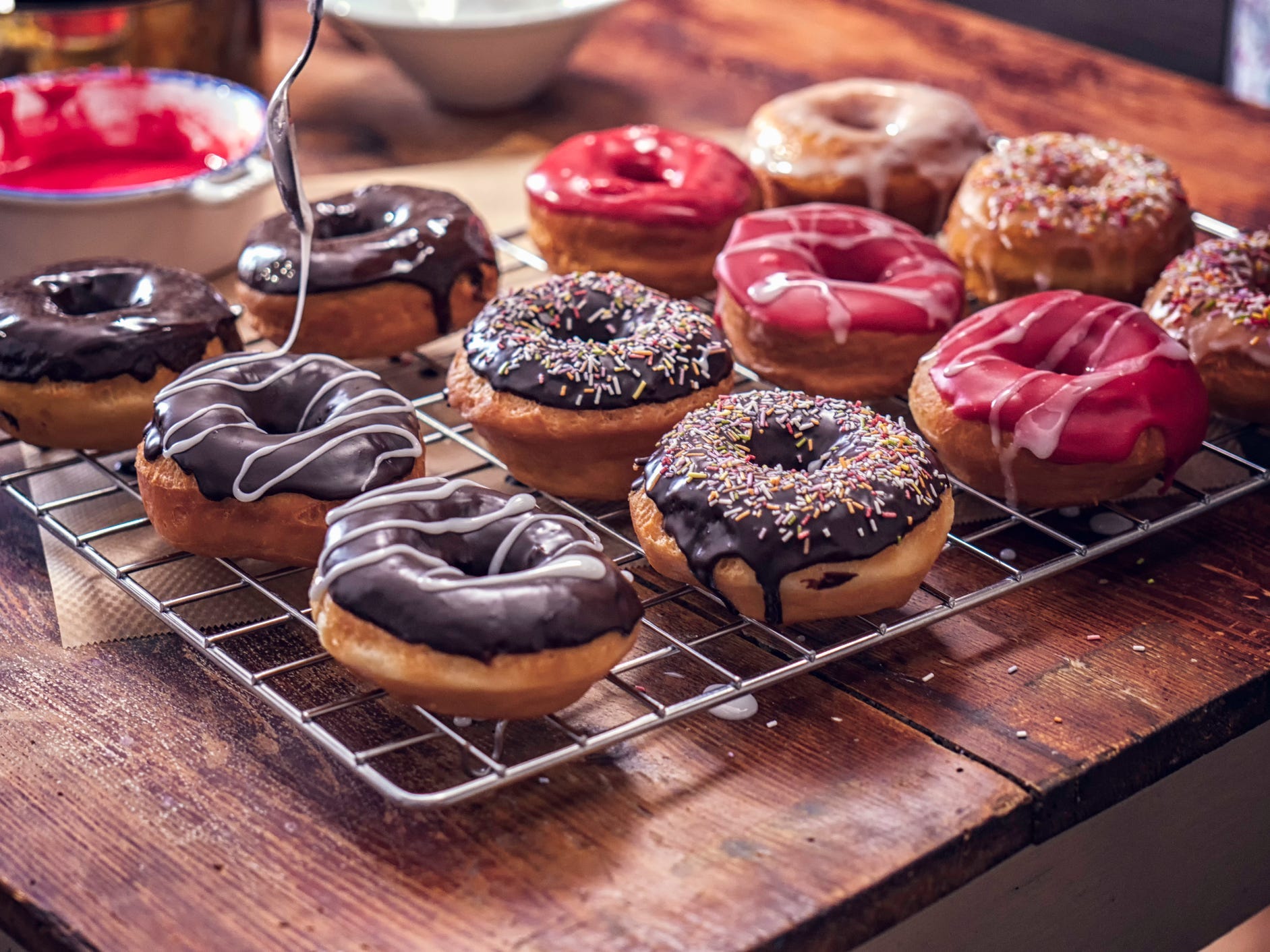 Different flavored donuts on a cooling rack.