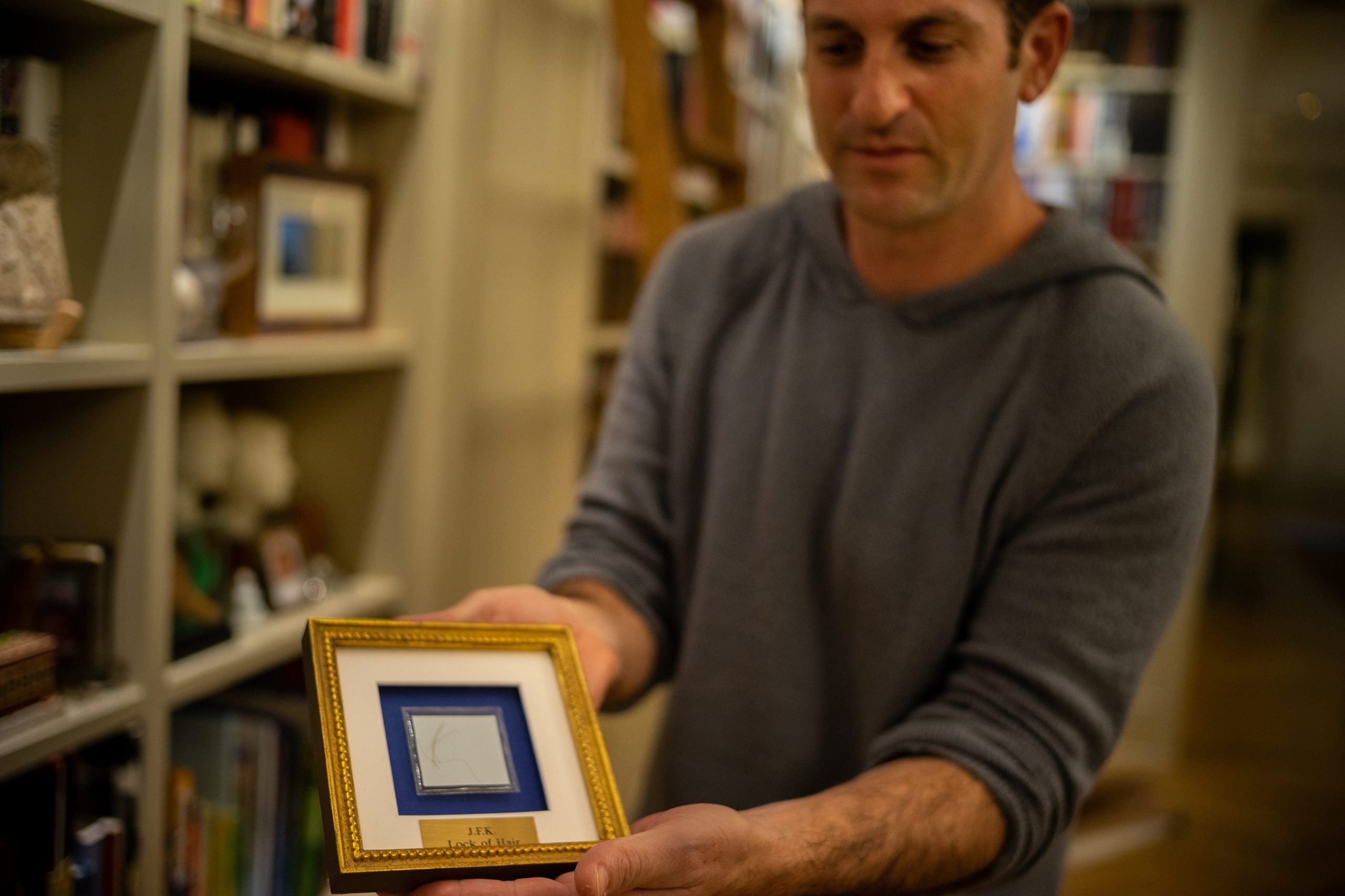 A man displays a framed item.