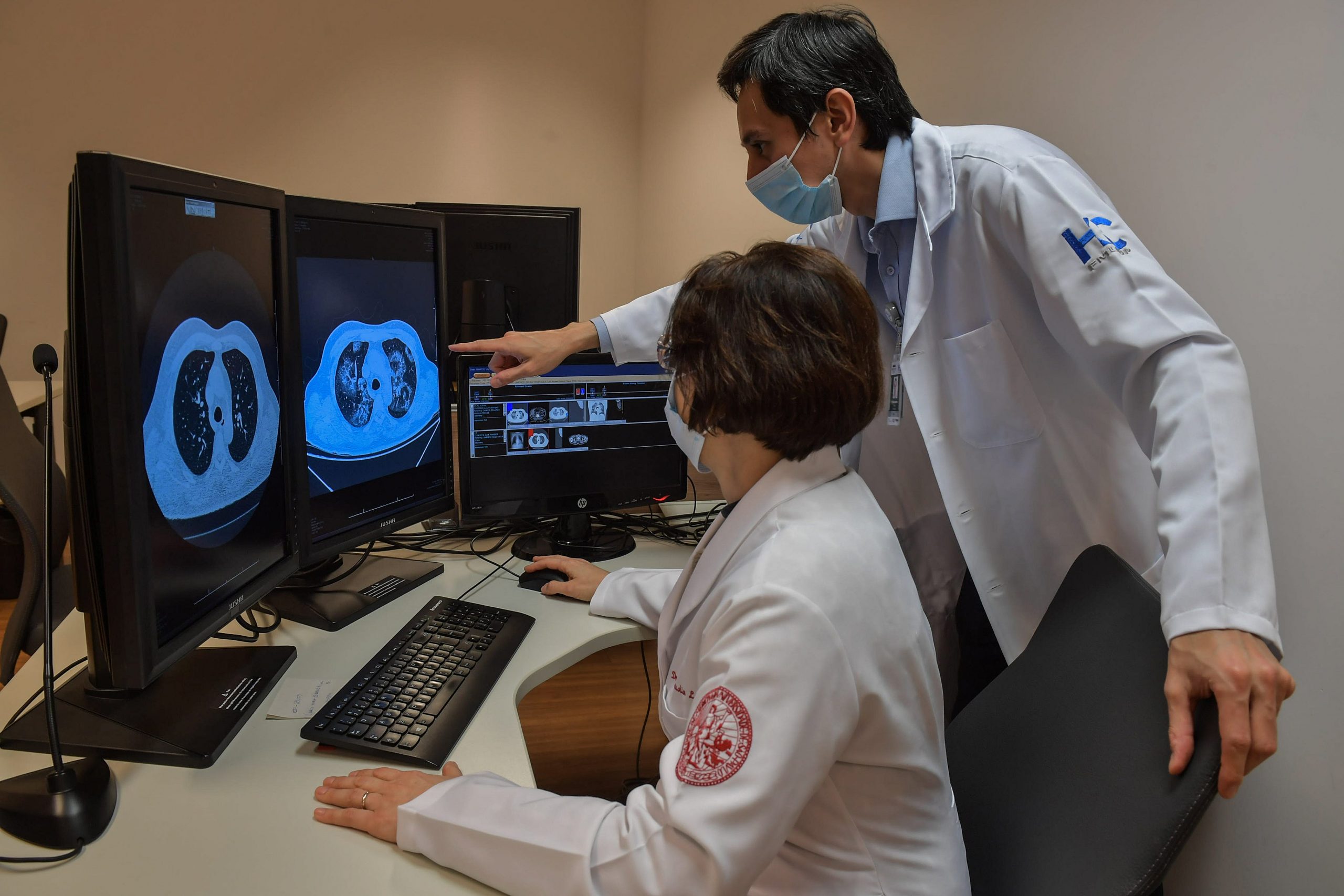 Two doctors observe an x-ray of a lung