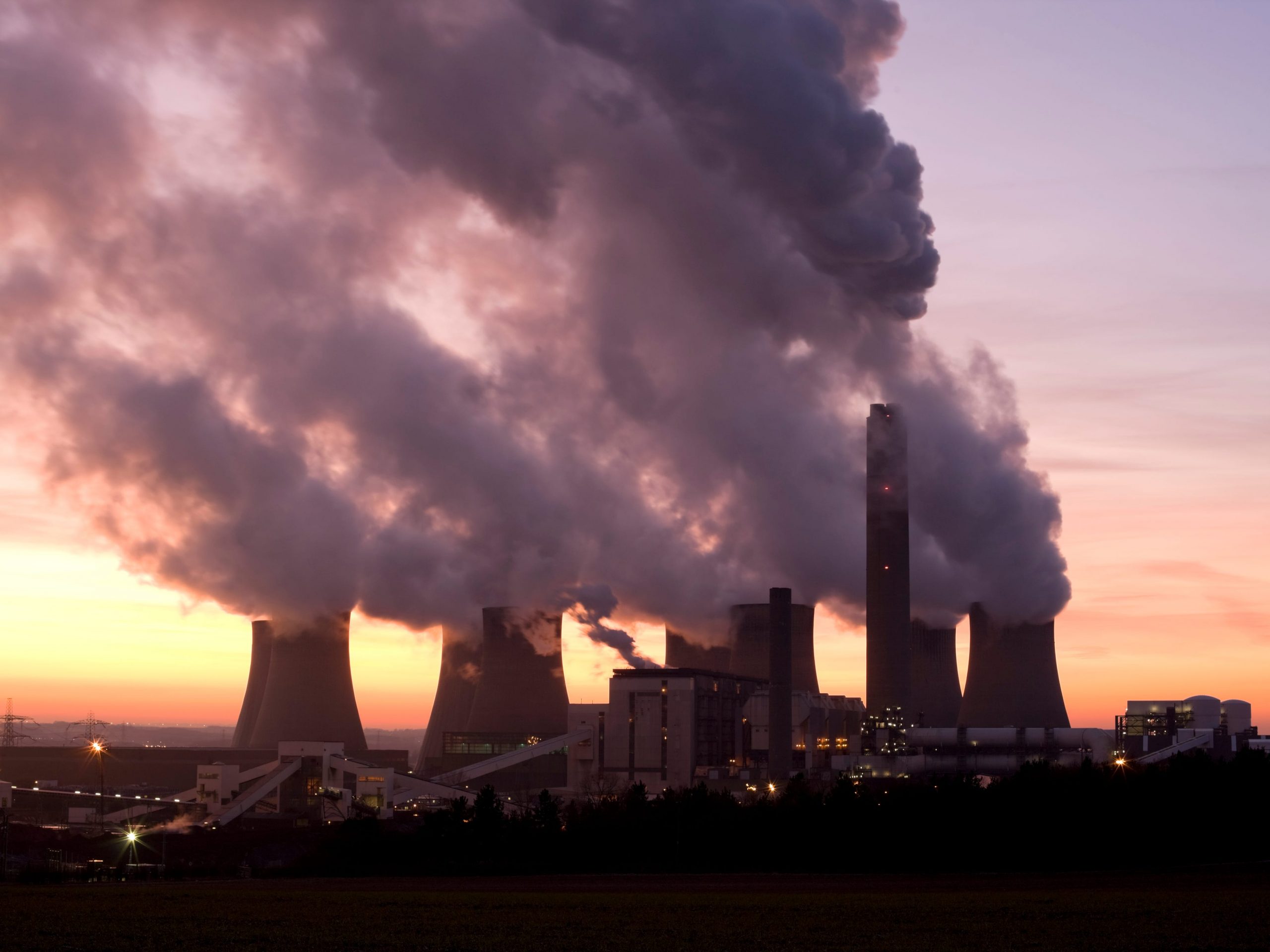 A coal fueled power station at sunset with smoke coming from its stacks, Ratcliffe-On-Soar, Nottingham, England, U.K.