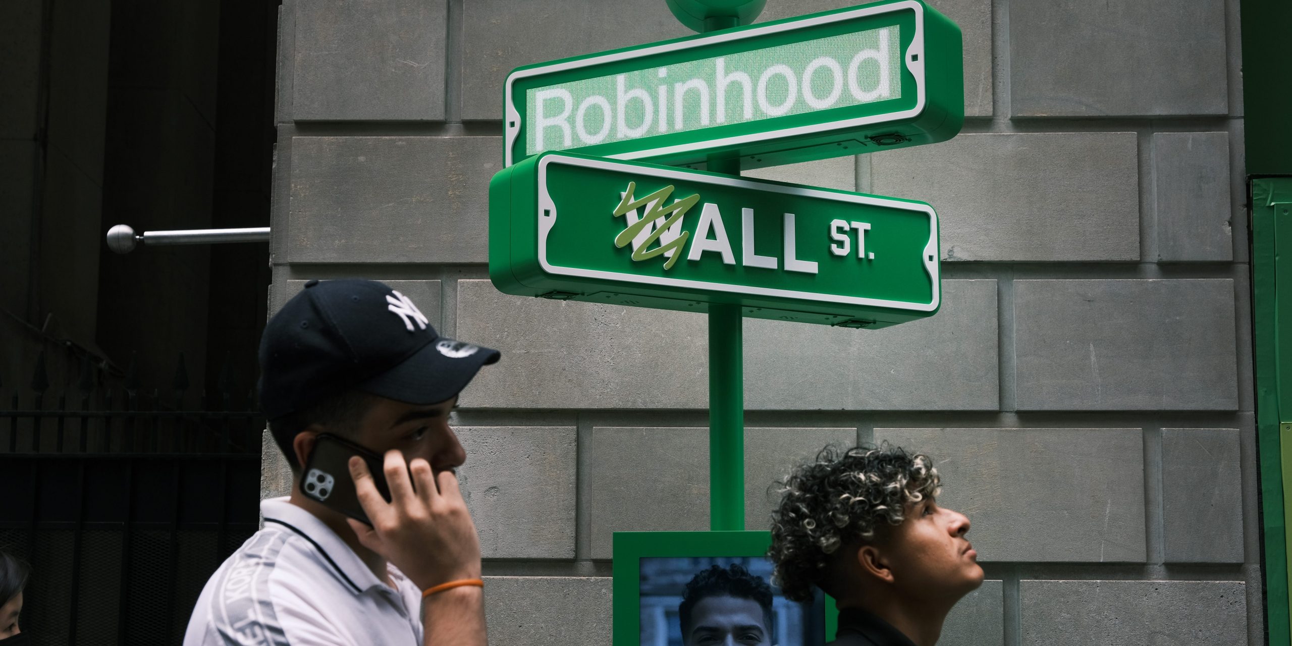 People wait in line for t-shirts at a pop-up kiosk for the online brokerage Robinhood along Wall Street after the company went public with an IPO earlier in the day on July 29, 2021 in New York City.