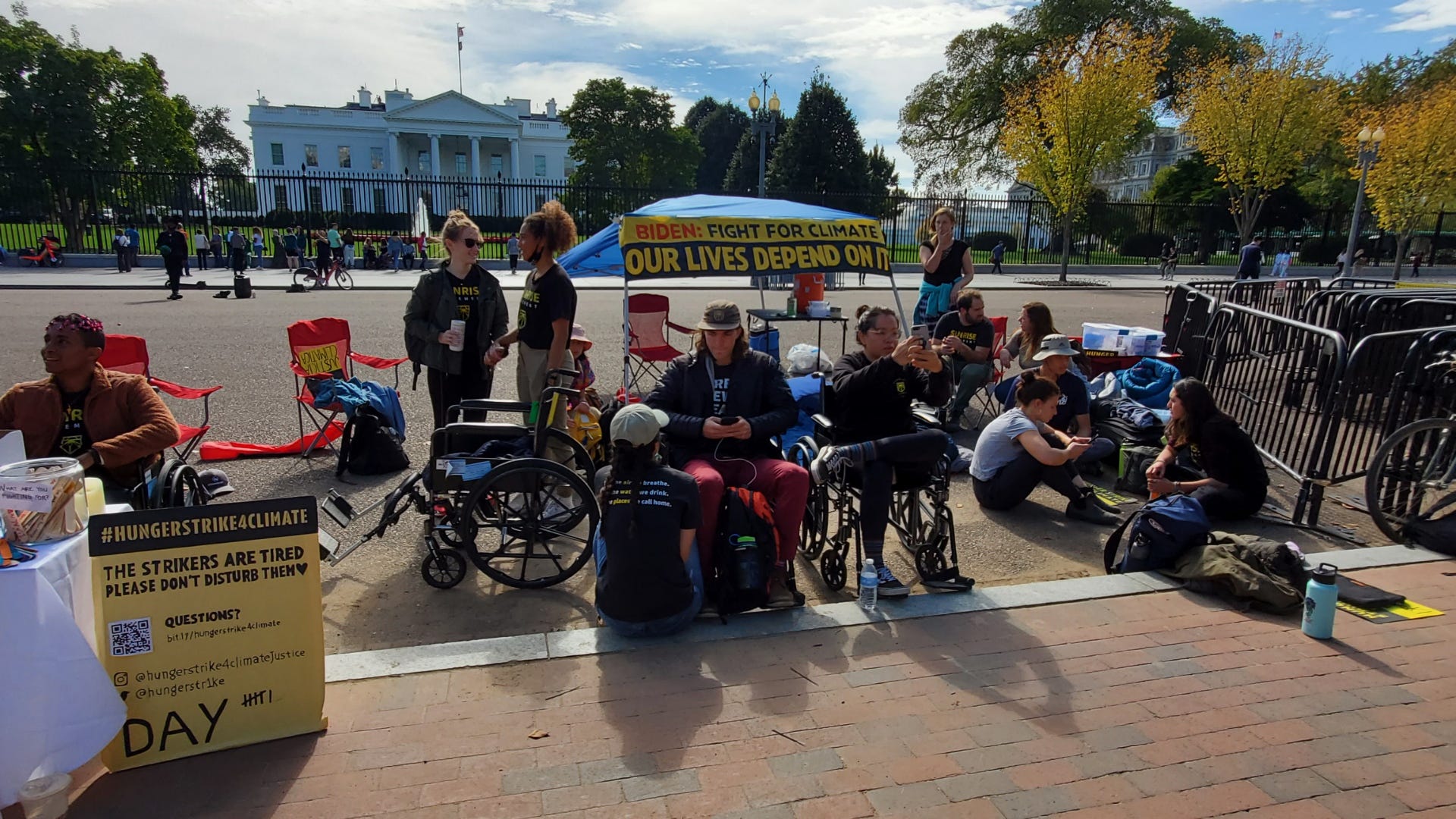 Climate justices activists sit, hold signs while staging a hunger strike outside the White House.