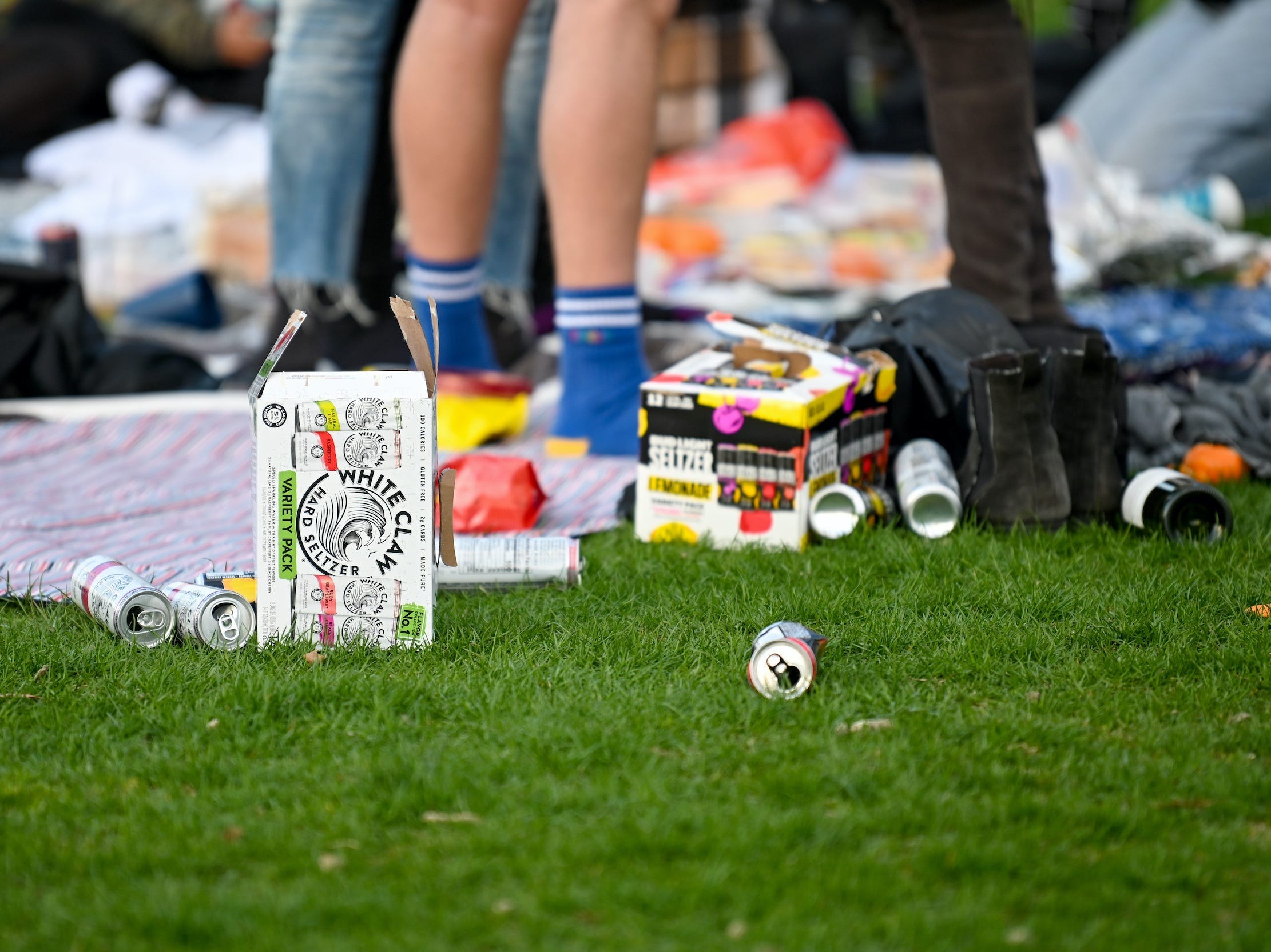 Empty White Claw and Bud Light Seltzer cans on the ground in Central Park during picnic