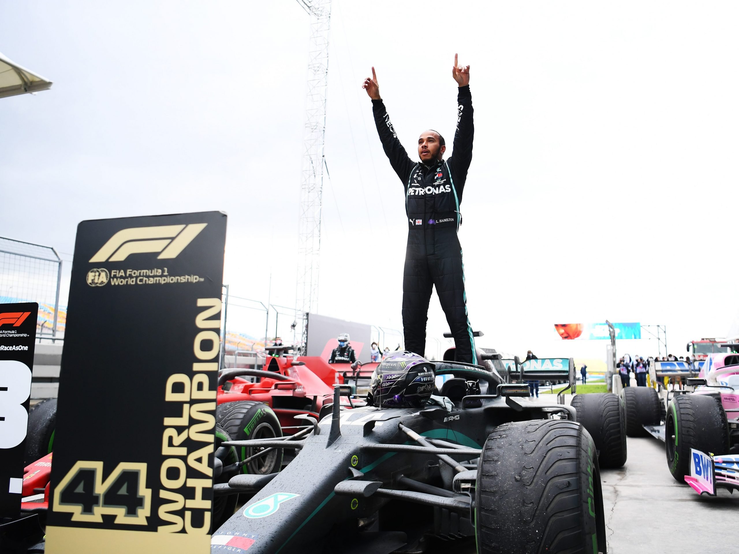 Lewis Hamilton stands on top of his car and celebrates