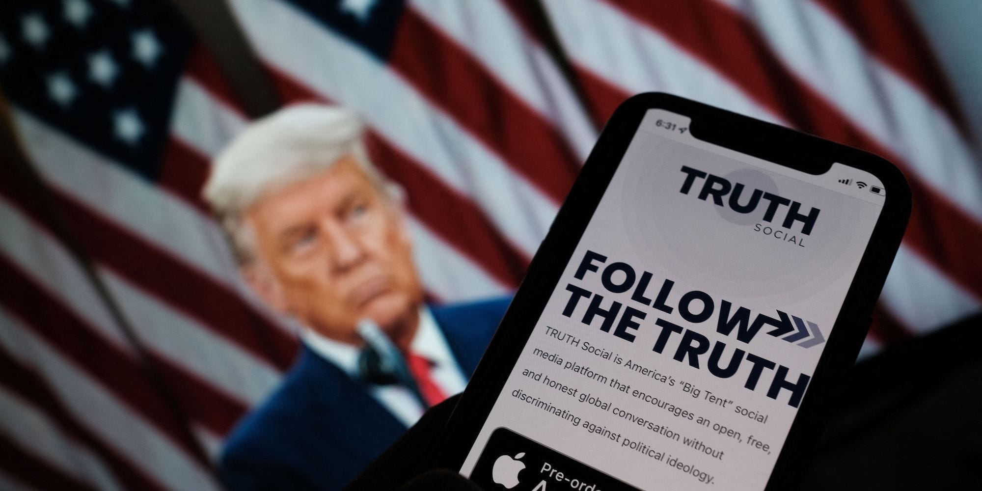 A photo illustration showing a person checking the app store on a smartphone for "Truth Social", with a photo of former President Donald Trump in the background.