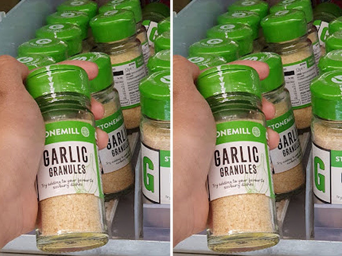 Hand holding a green and clear package of Aldi garlic granules