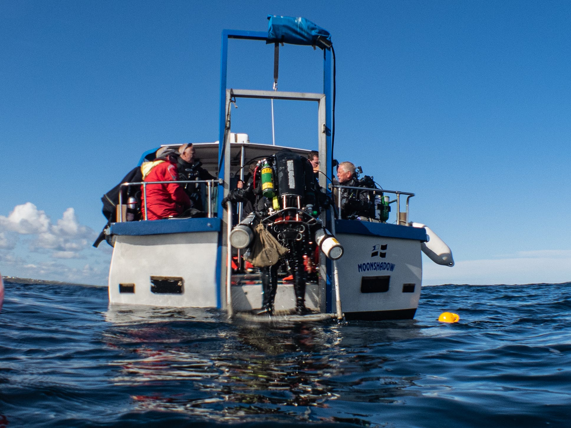 A diver and support crew aboard the Moonshadow