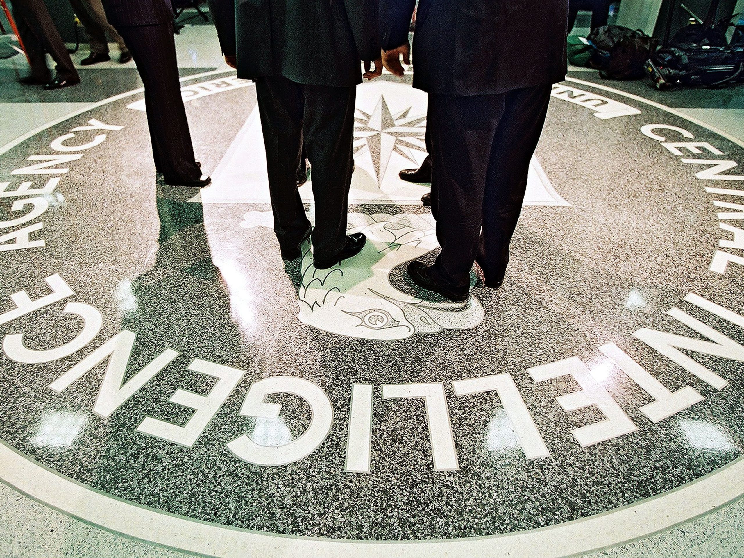 people standing on CIA logo in CIA headquarters