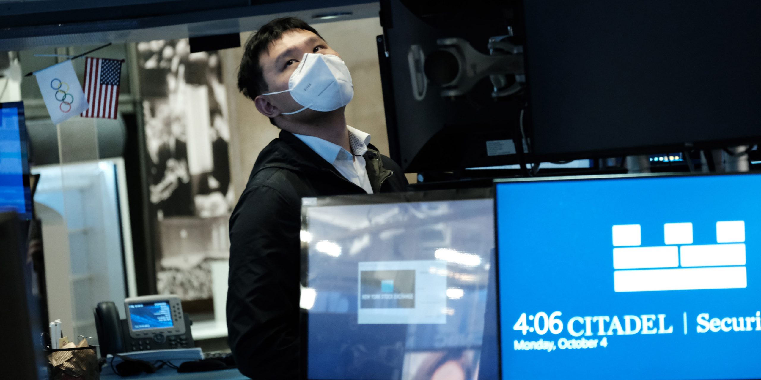 A trader wearing a mask works on the floor of the New York Stock Exchange