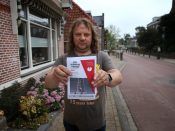Een inwoner van het Friese dorp Ternaard houdt een pamflet vast waarop het protest tegen gaswinning wordt aangekondigd.