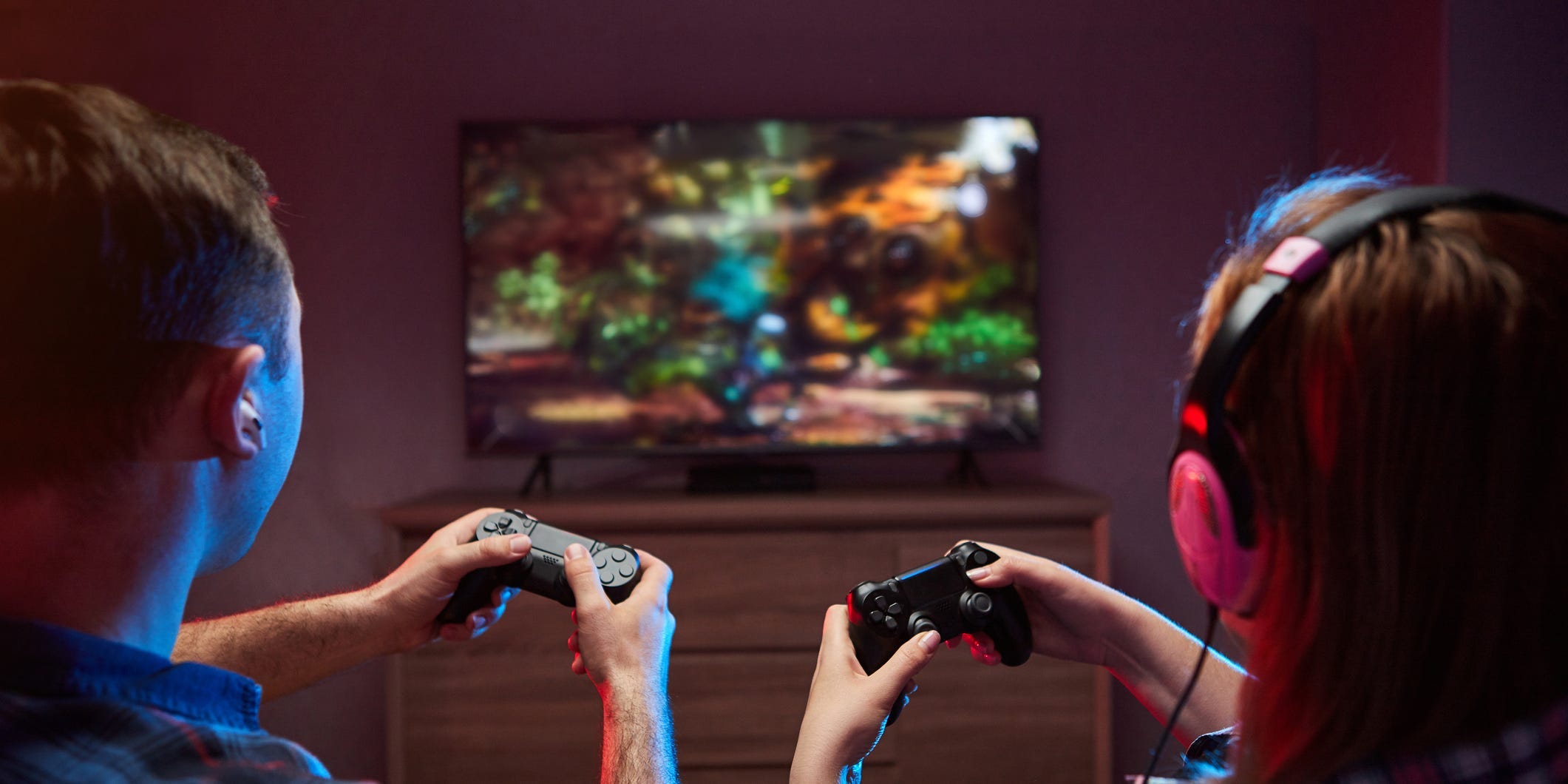 Two people playing PlayStation console