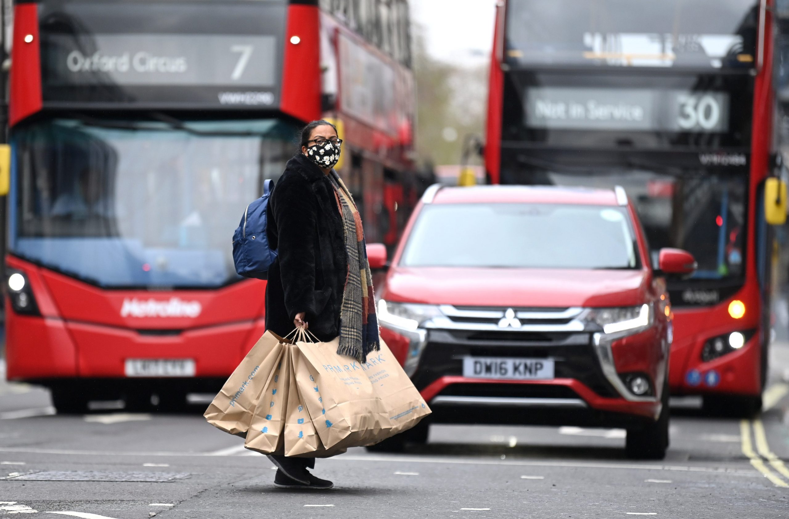 UK woman shopping shops red bus economy reopens London