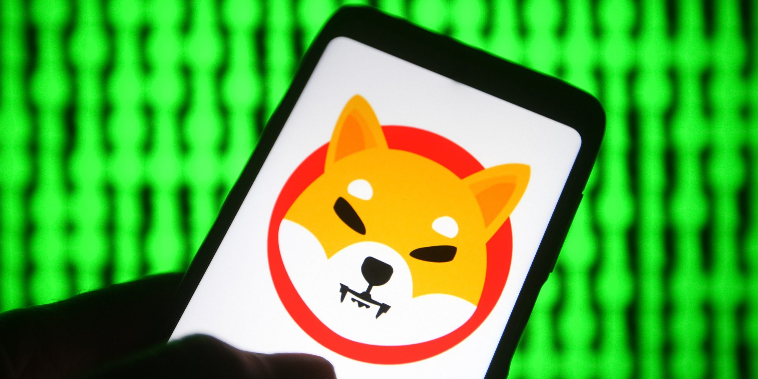 In this photo illustration, a cryptocurrency Shiba Token $SHIB logo is seen on a smartphone with a pc screen in the background.