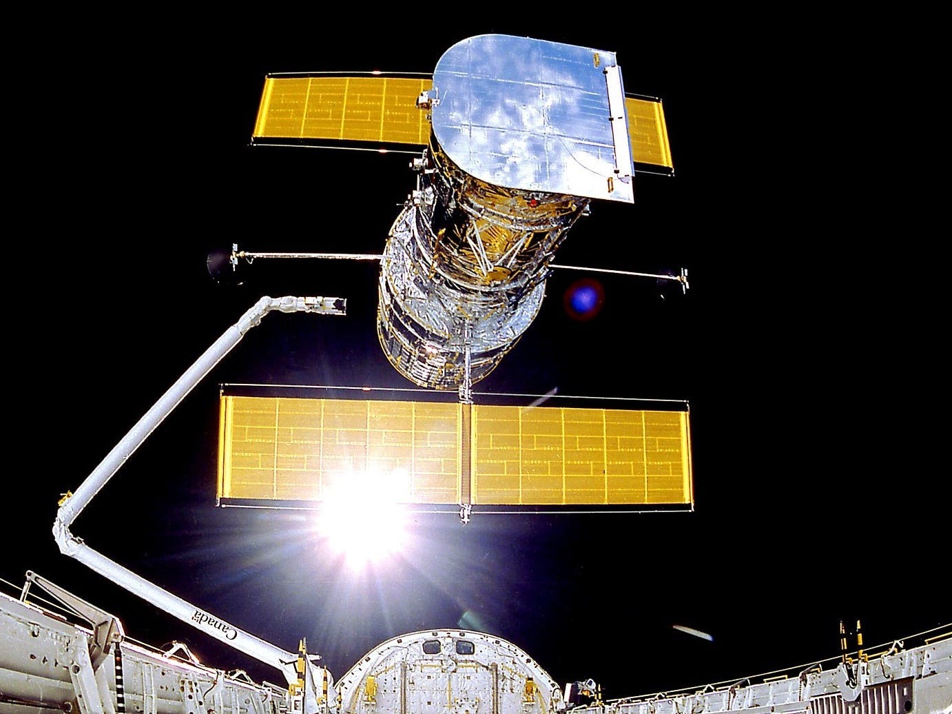 hubble space telesope deploys from space shuttle arm in earth orbit