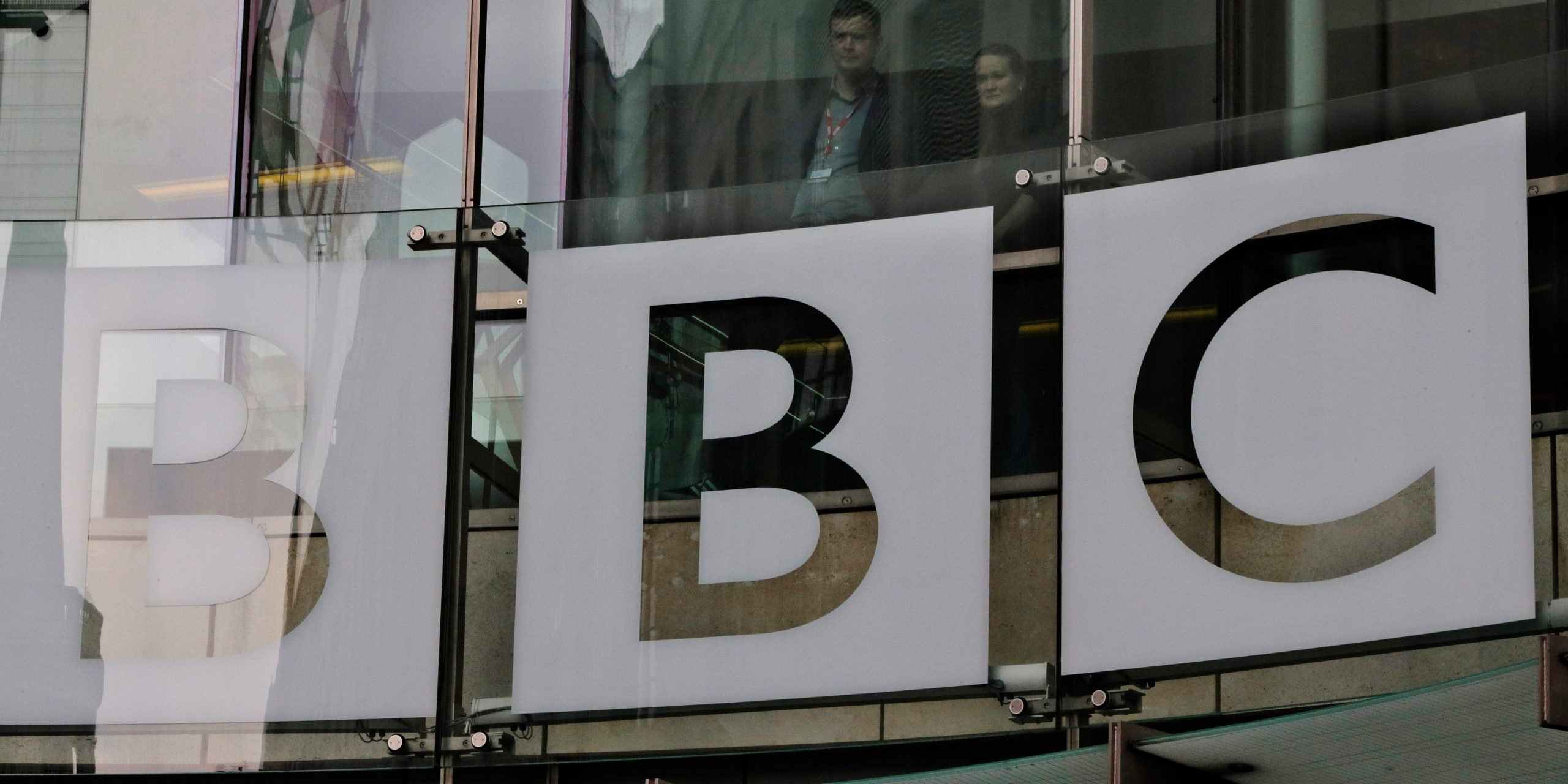 People watch from inside BBC's New Broadcasting House, as BBC journalists and technical staff on strike, not seen, form a picket line outside the building in central London, Thursday, March 28, 2013.