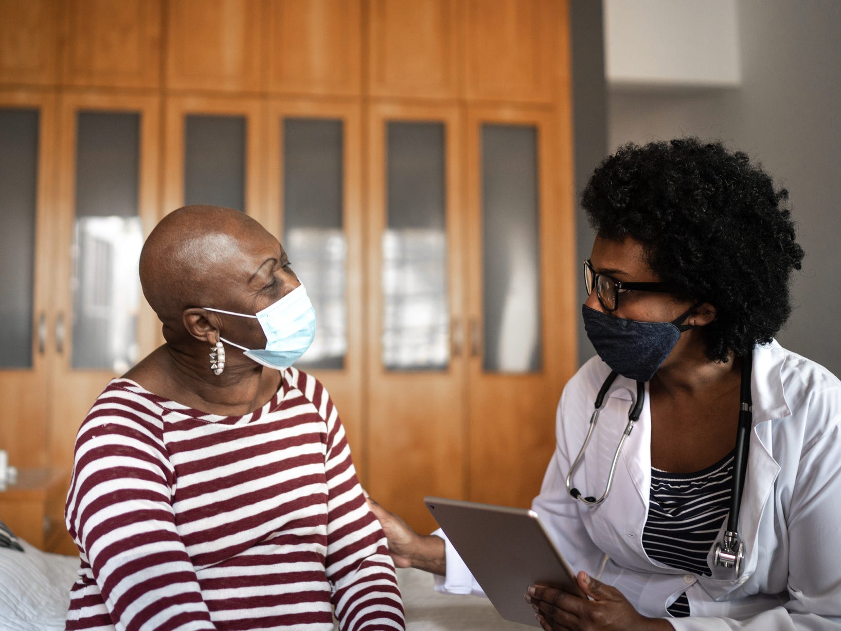 A woman and her doctor talking with masks