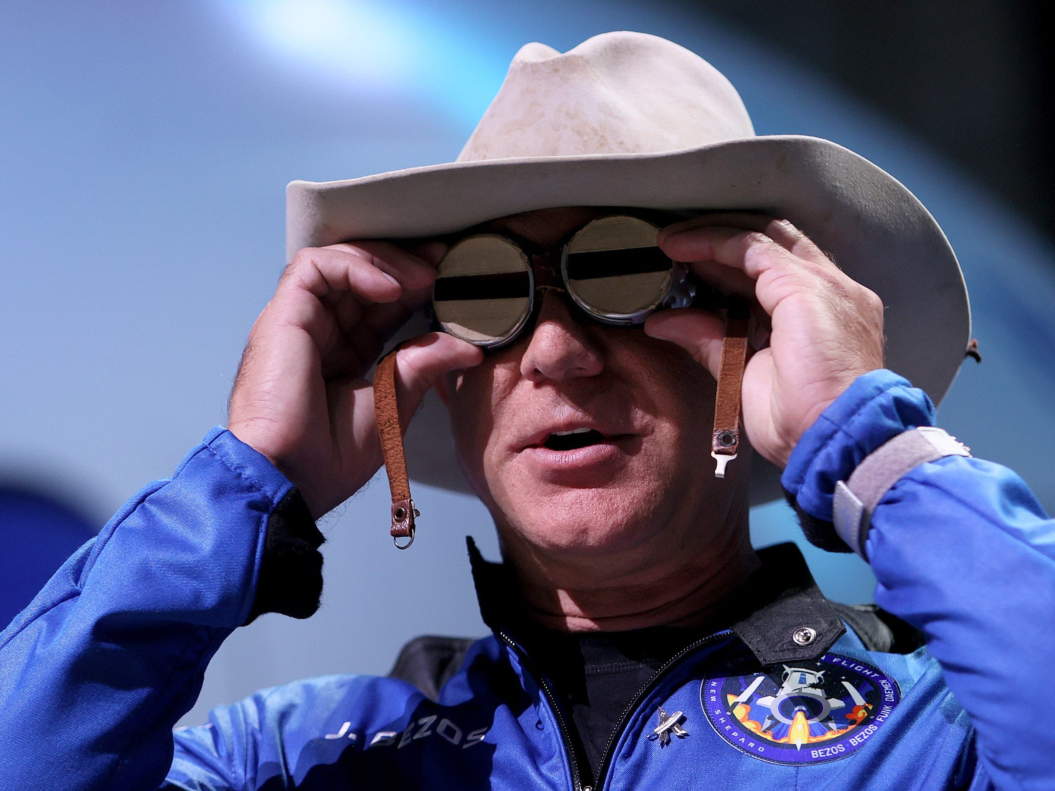 Blue Origin founder Jeff Bezos wears a pair of reflective aviation glasses under a cowboy hat