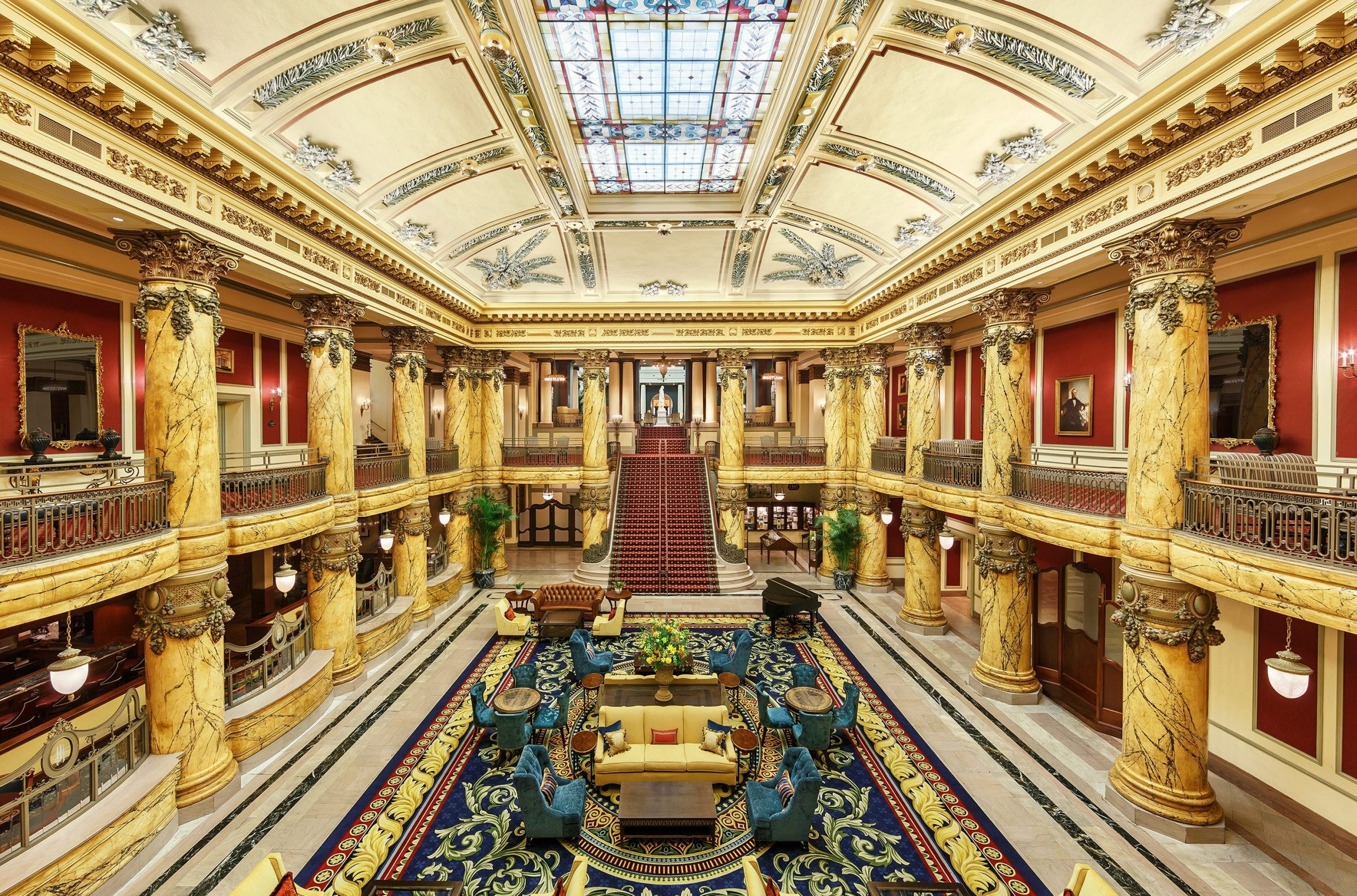 The elegant golden rotunda and grand staircase of The Jefferson Hotel