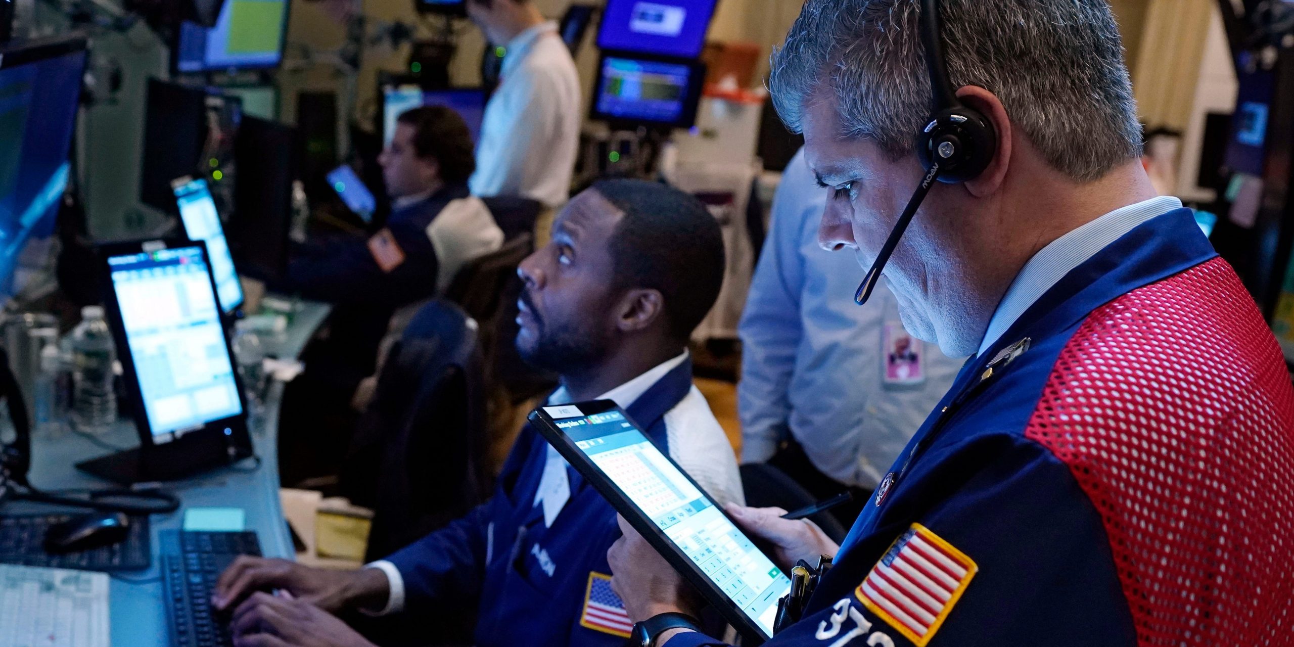 Traders Aaron Ford, left, and John Panin work on the floor of the New York Stock Exchange wall street stocks