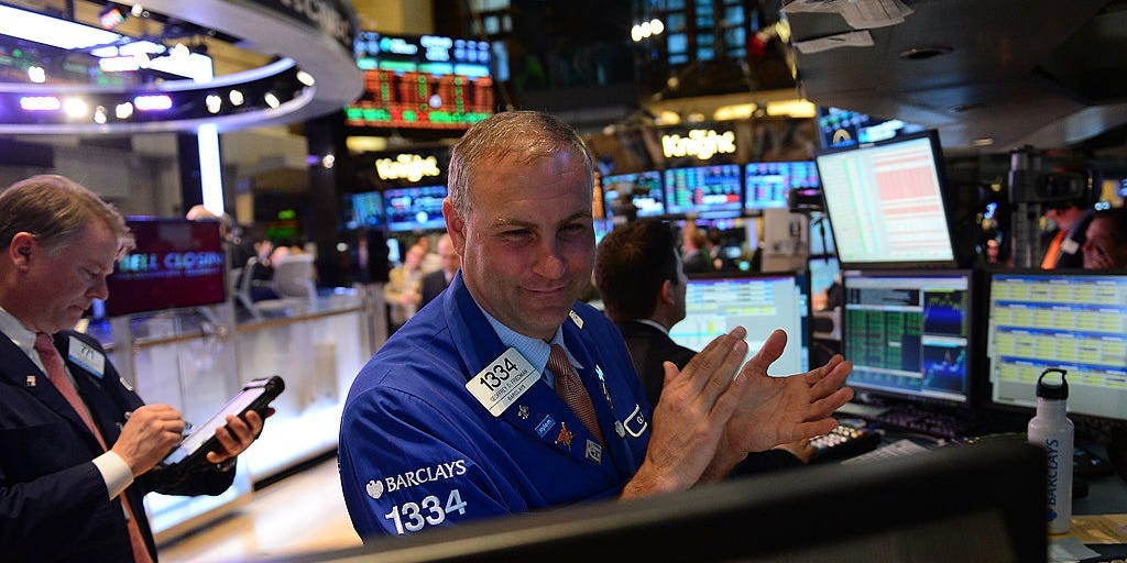 A stock trader claps at the end of trade at the New York Stock Exchange