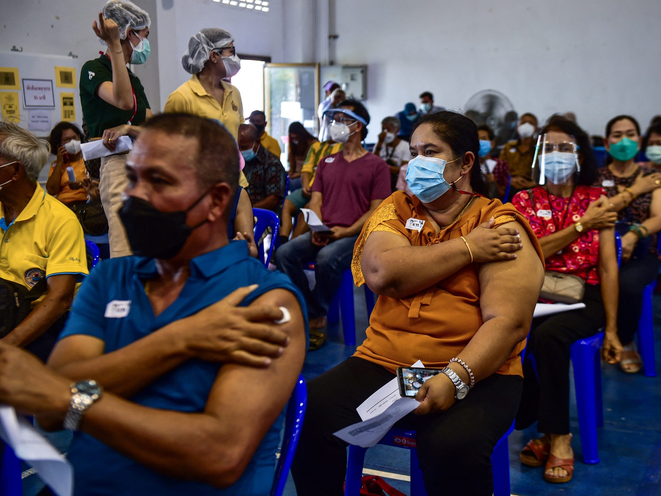 People hold their plaster patches after being administered doses of the AstraZeneca Covid-19 coronavirus vaccine at the Narathiwat Hospital compound in the southern province of Narathiwat on June 7, 2021, as mass vaccination rollouts begin in Thailand.