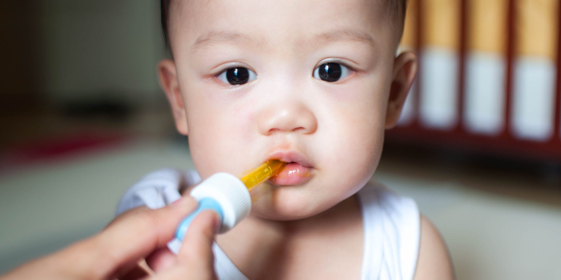 Toddler with an eye dropper in their mouth.