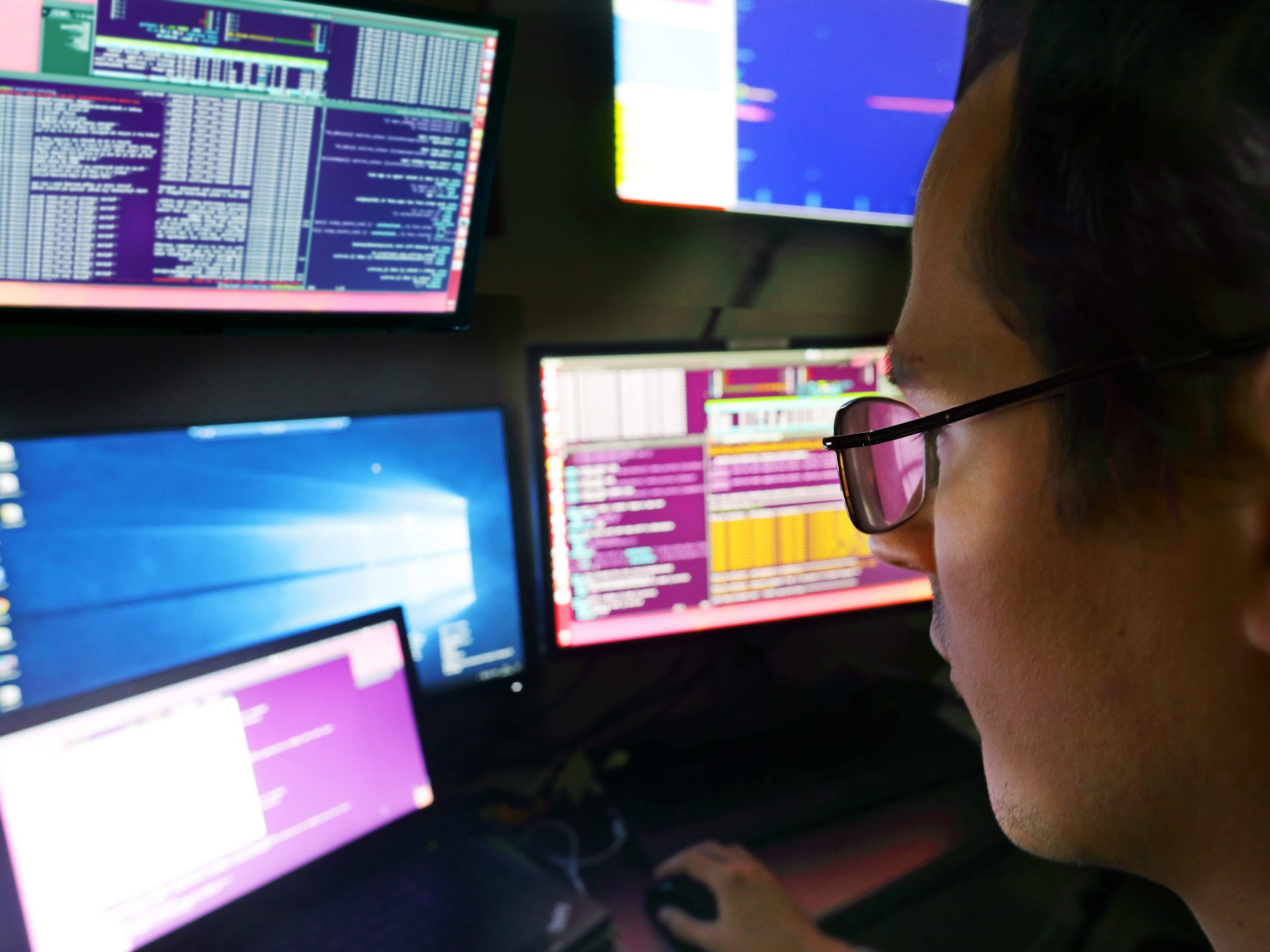 Man looking at multiple computer screens.