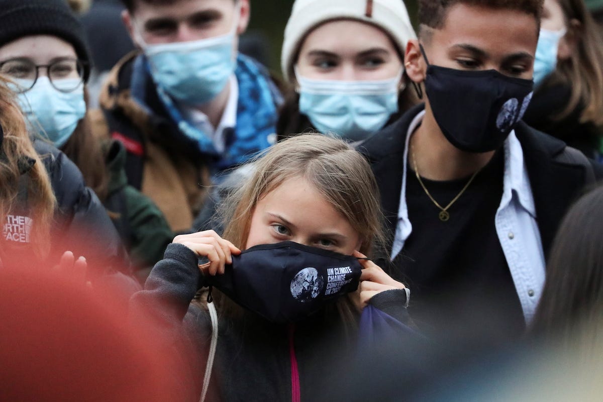 Swedish activist Greta Thunberg adjusts her mask at the Festival Park as the UN Climate Change Conference (COP26) takes place in Glasgow, Scotland, Britain, November 1, 2021. REUTERS/Russell Cheyne