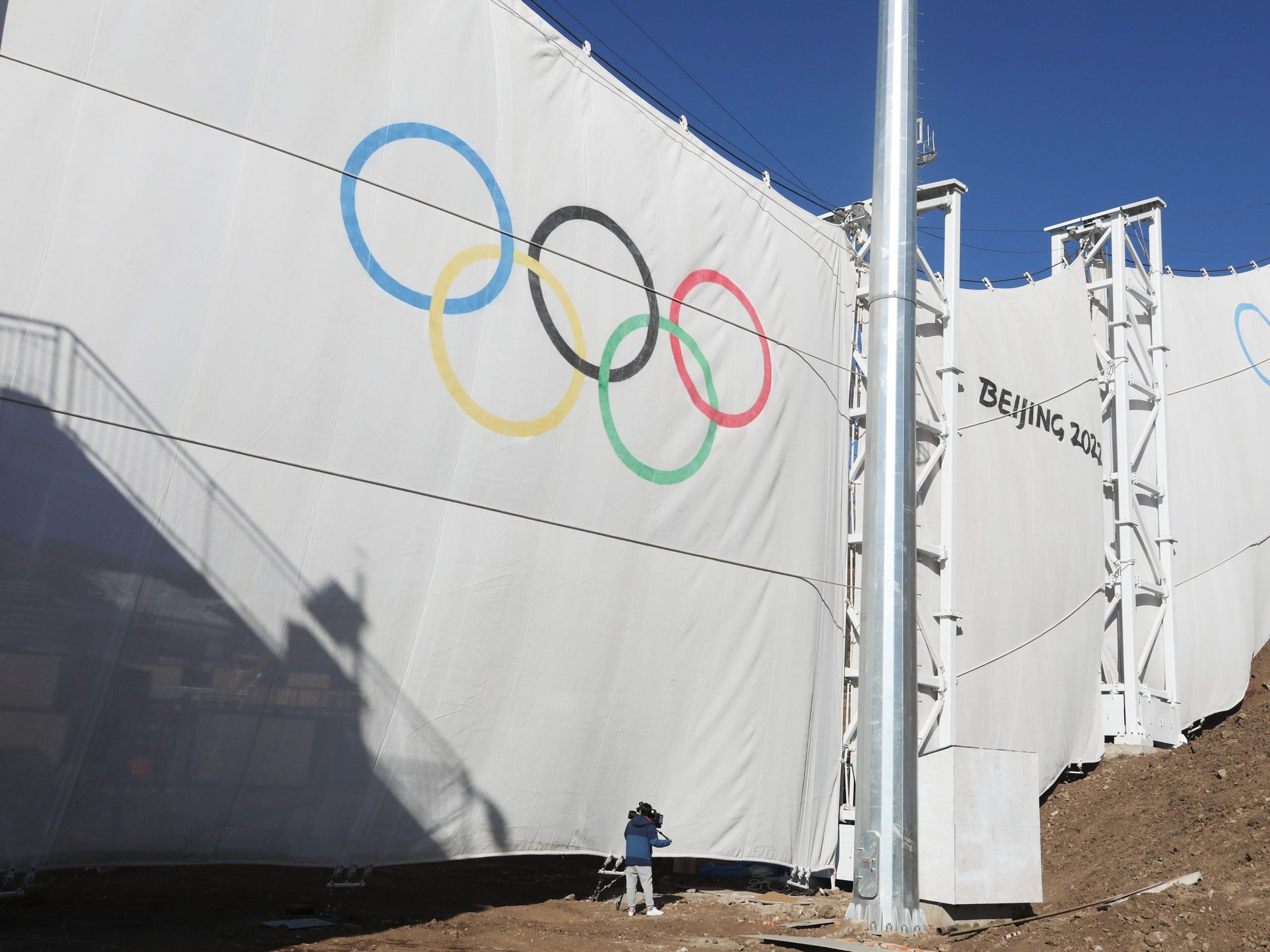 Workers hang up windbreaks at at the Genting Snow Park where the freestyle skiing and snowboarding matches will be held during Beijing 2022 Winter Olympics