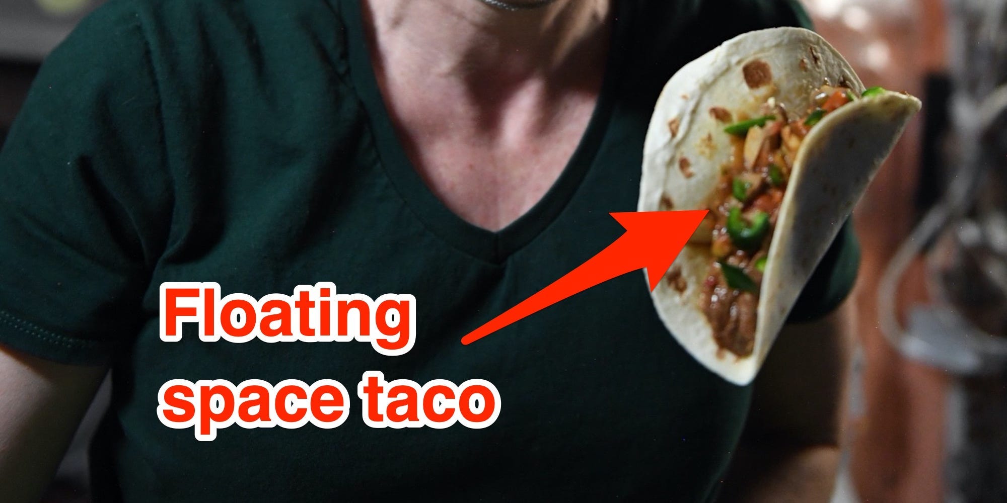 A female astronaut smiles while a taco floats beside her