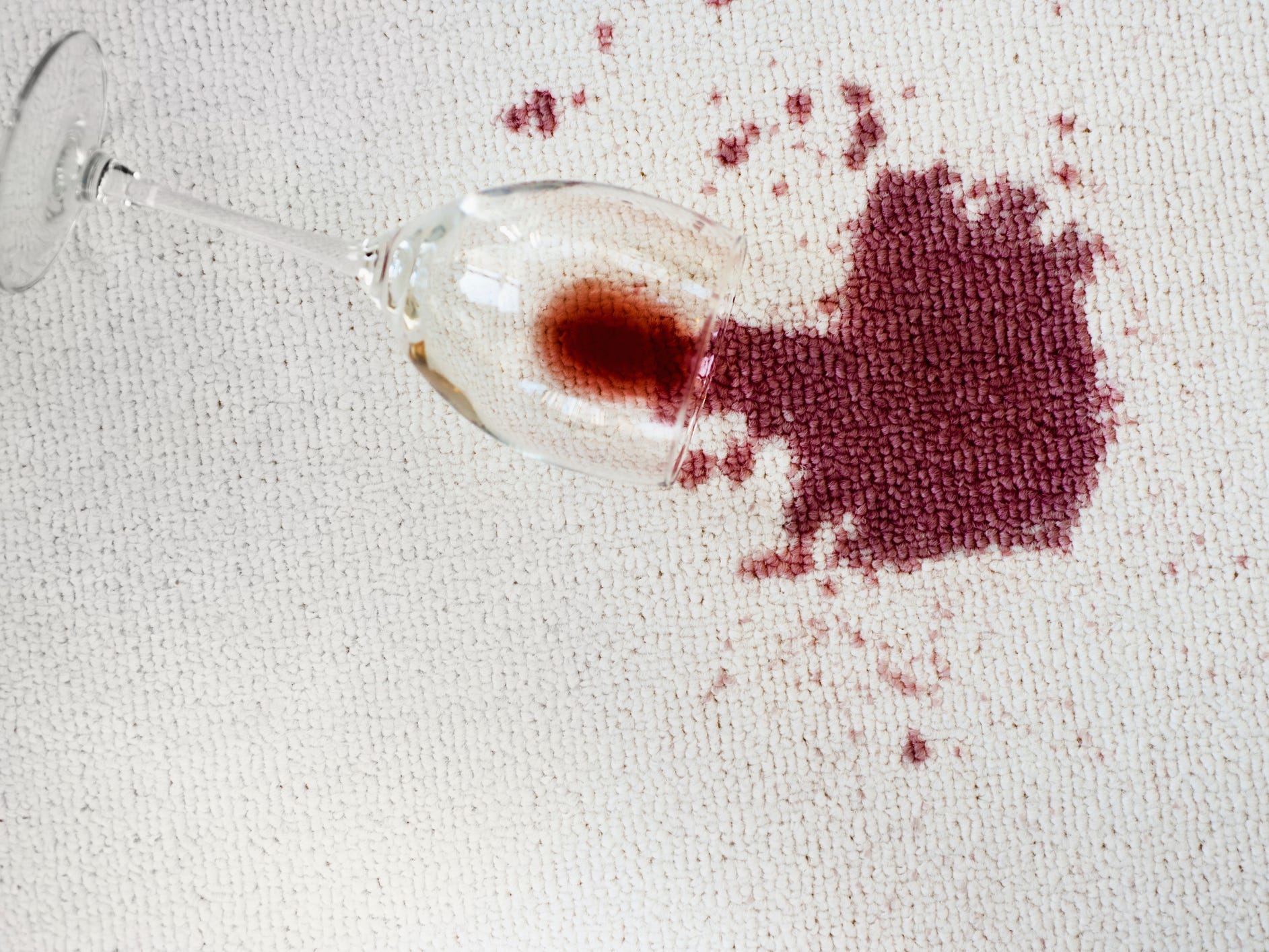 Spilled red wine on a white carpet.