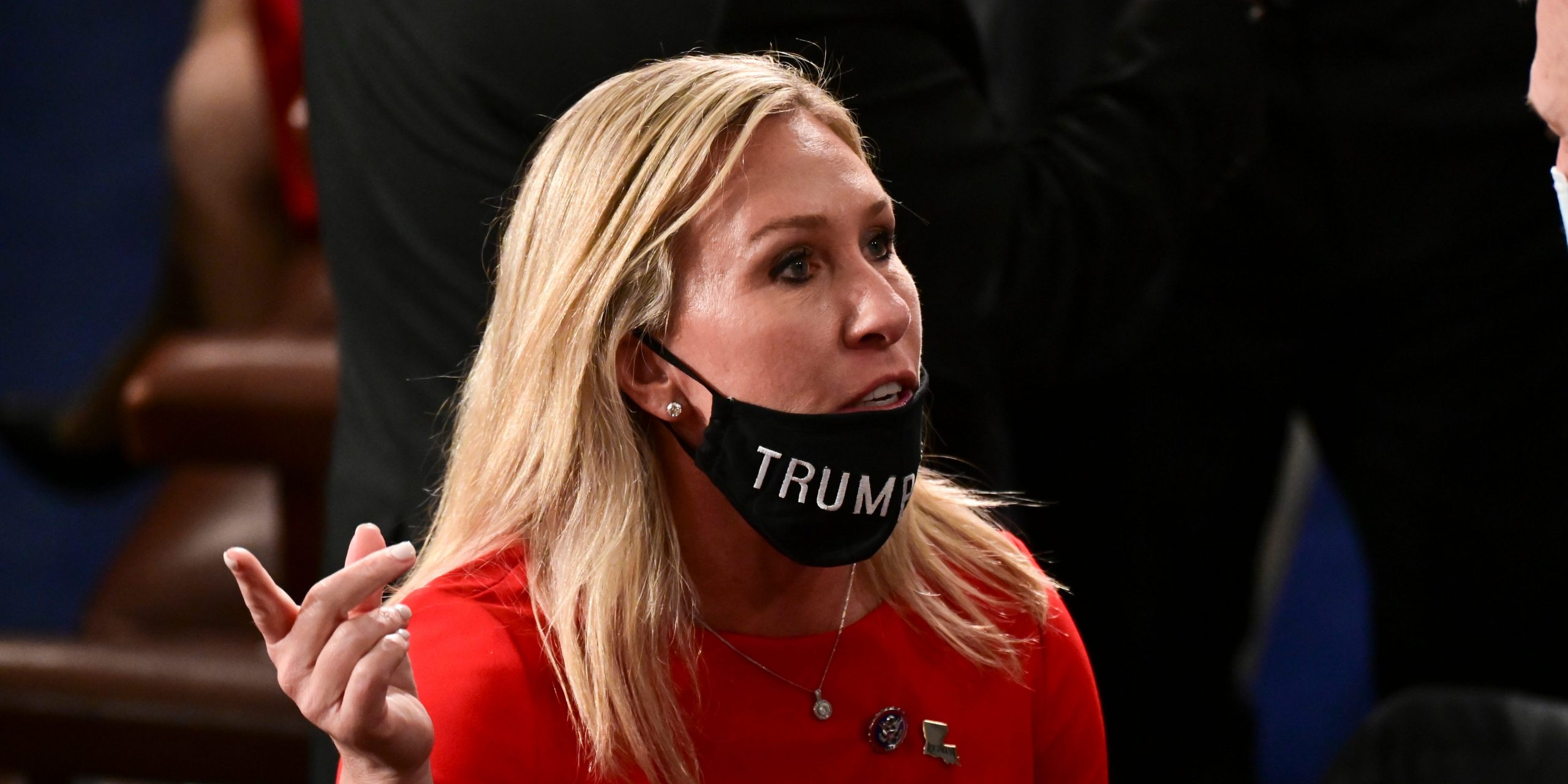 Rep. Marjorie Taylor Greene, R-Ga, speaks to a colleague with her "Trump Won" face mask pulled down below her mouth on the floor of the House before taking the oath of office on opening day of the 117th Congress at the U.S. Capitol in Washington, Sunday, Jan. 3, 2021.