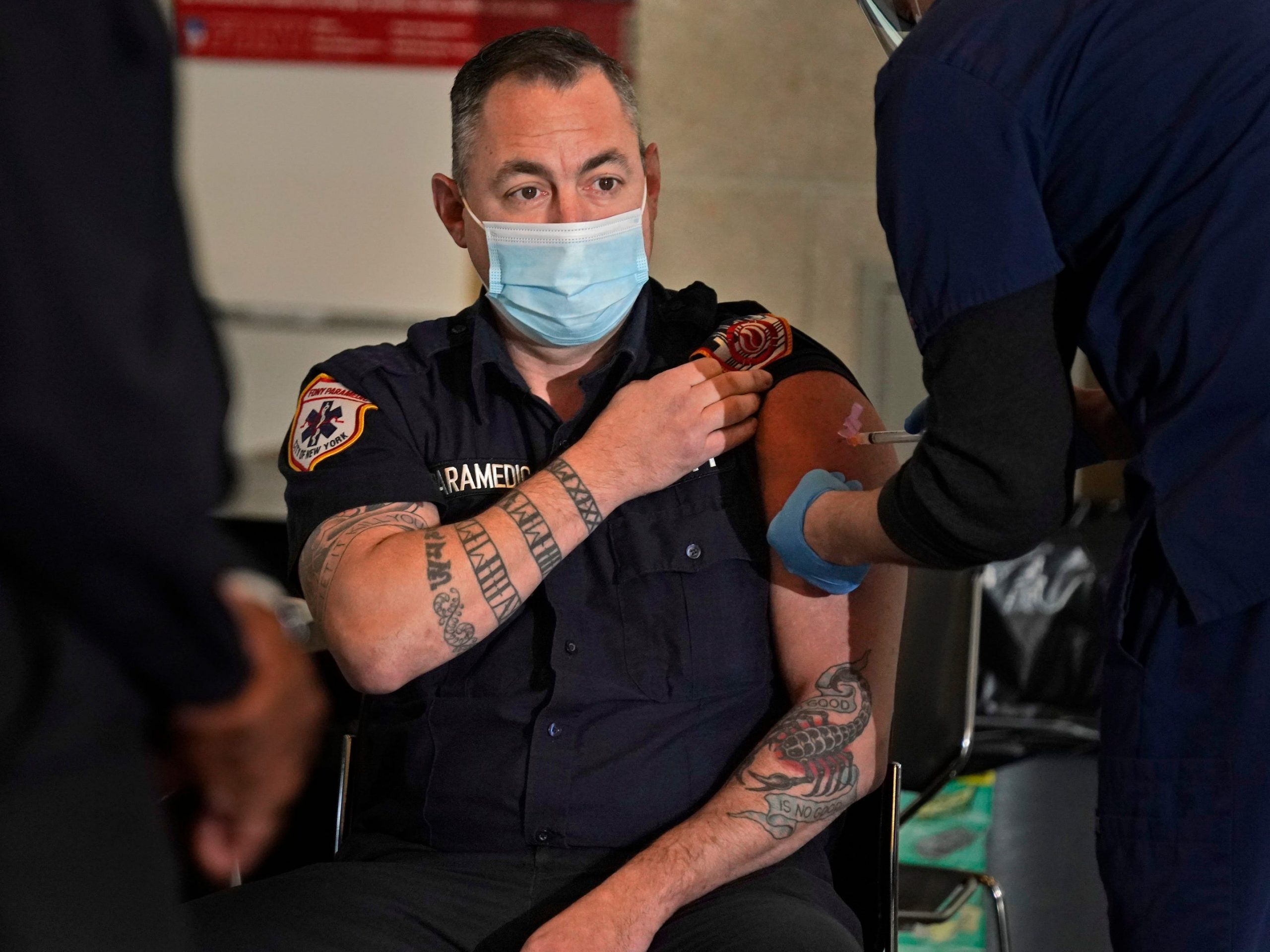 A New York City firefighter emergency medical services personnel gets vaccinated.