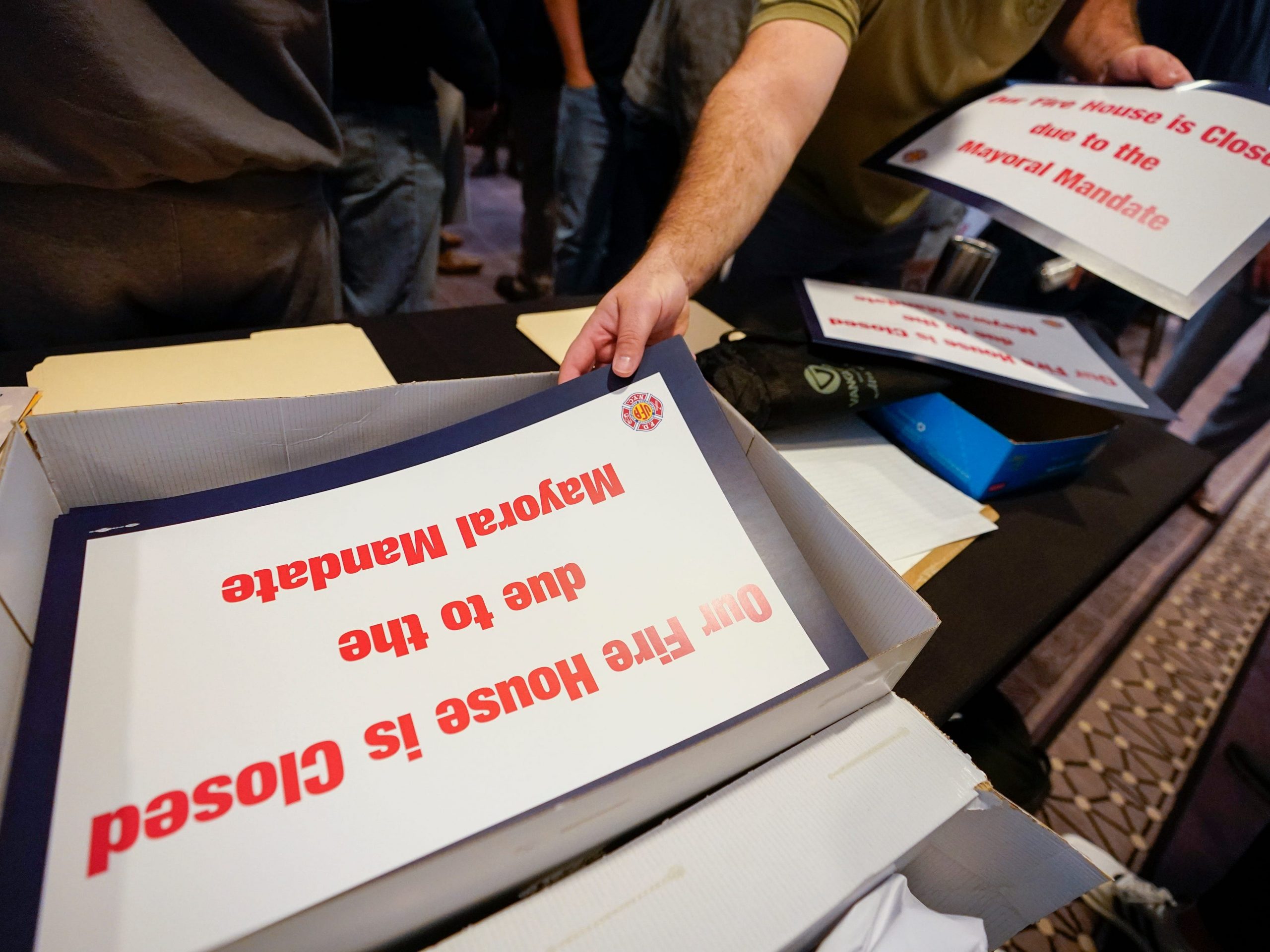 An FDNY firefighter picks up signs to display at his firehouse.