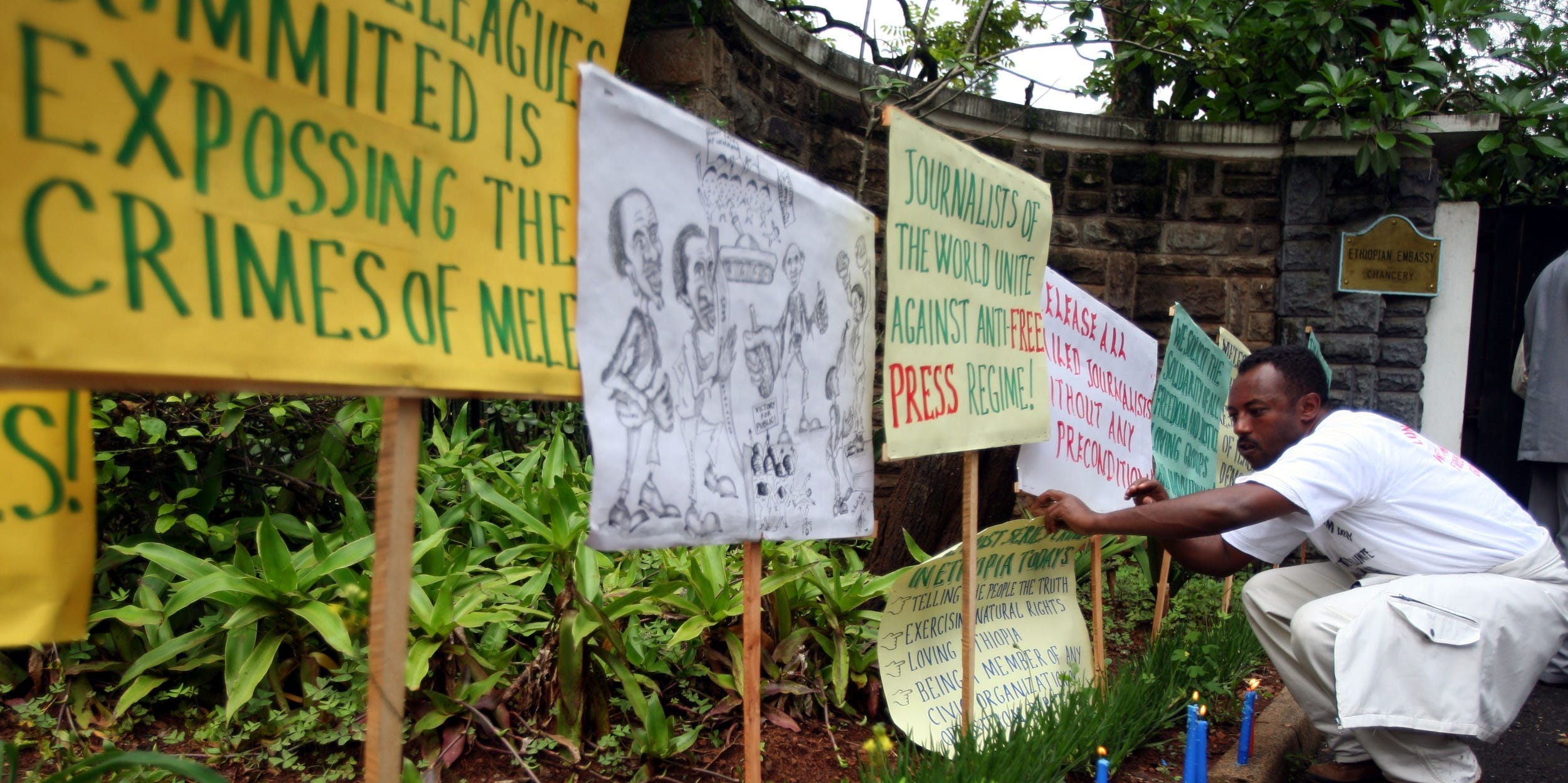 An expelled Ethiopian journalist places lit candles and banners in front of the Ethiopian embassy in Nairobi, Kenya May 2, 2006.