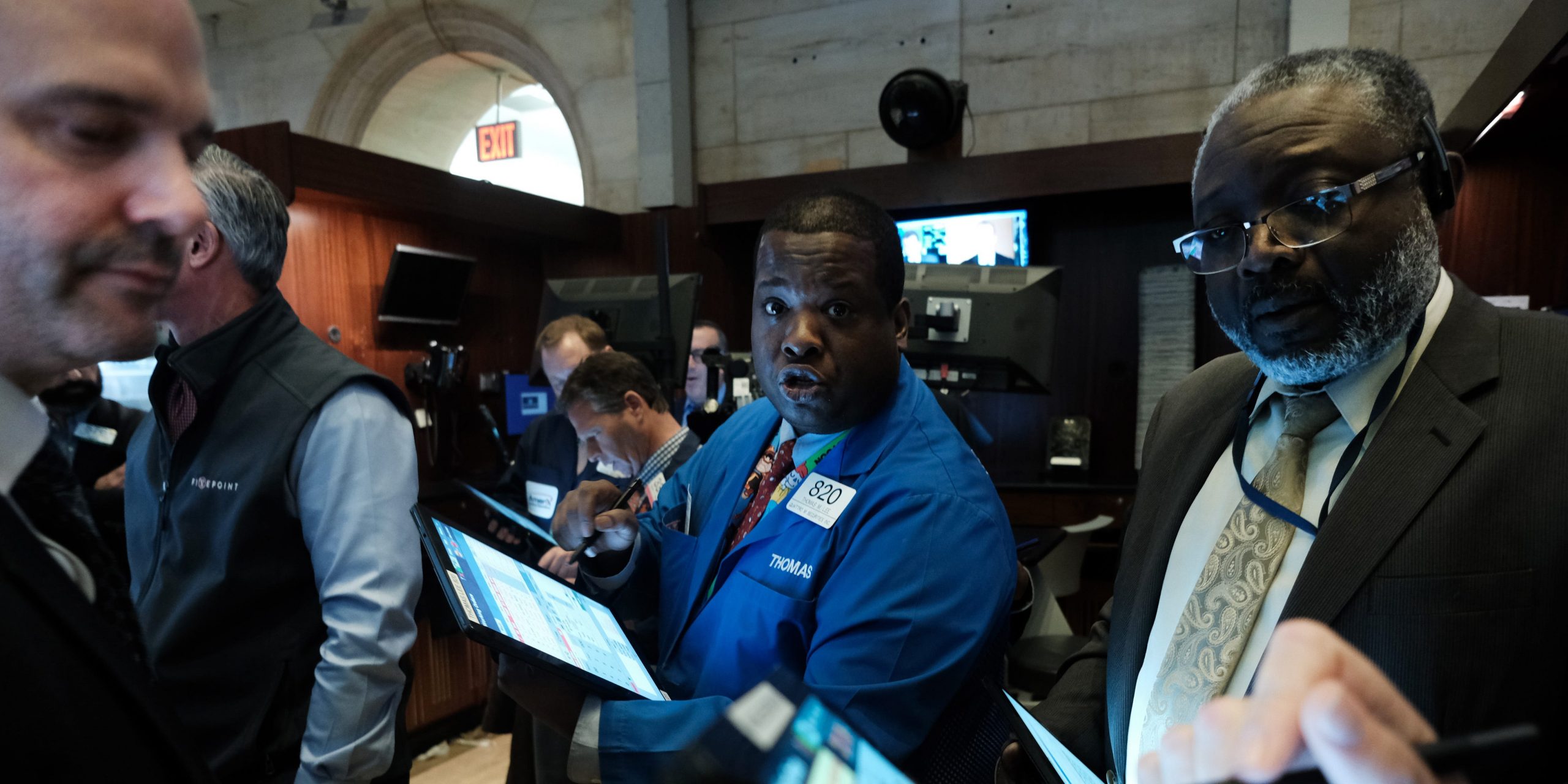 Three traders work on the floor of the New York Stock Exchange