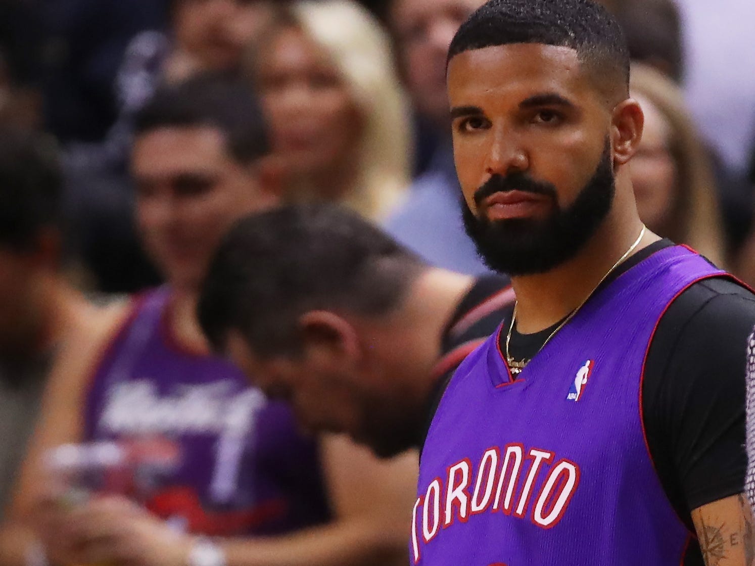 Drake wears a throwback Toronto Raptors jersey.