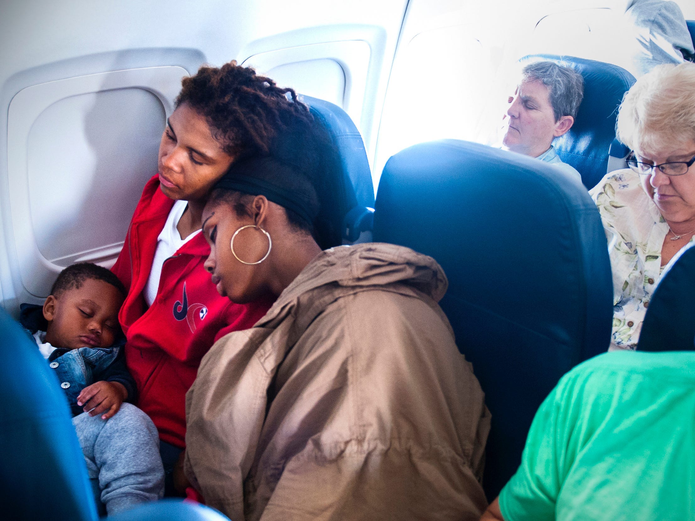 Former Washington Mystics player Tayler Hill and her son, Maurice, get some sleep on the shoulder of teammate Tierra Ruffin-Pratt while sitting in coach on a 2015 commercial flight.