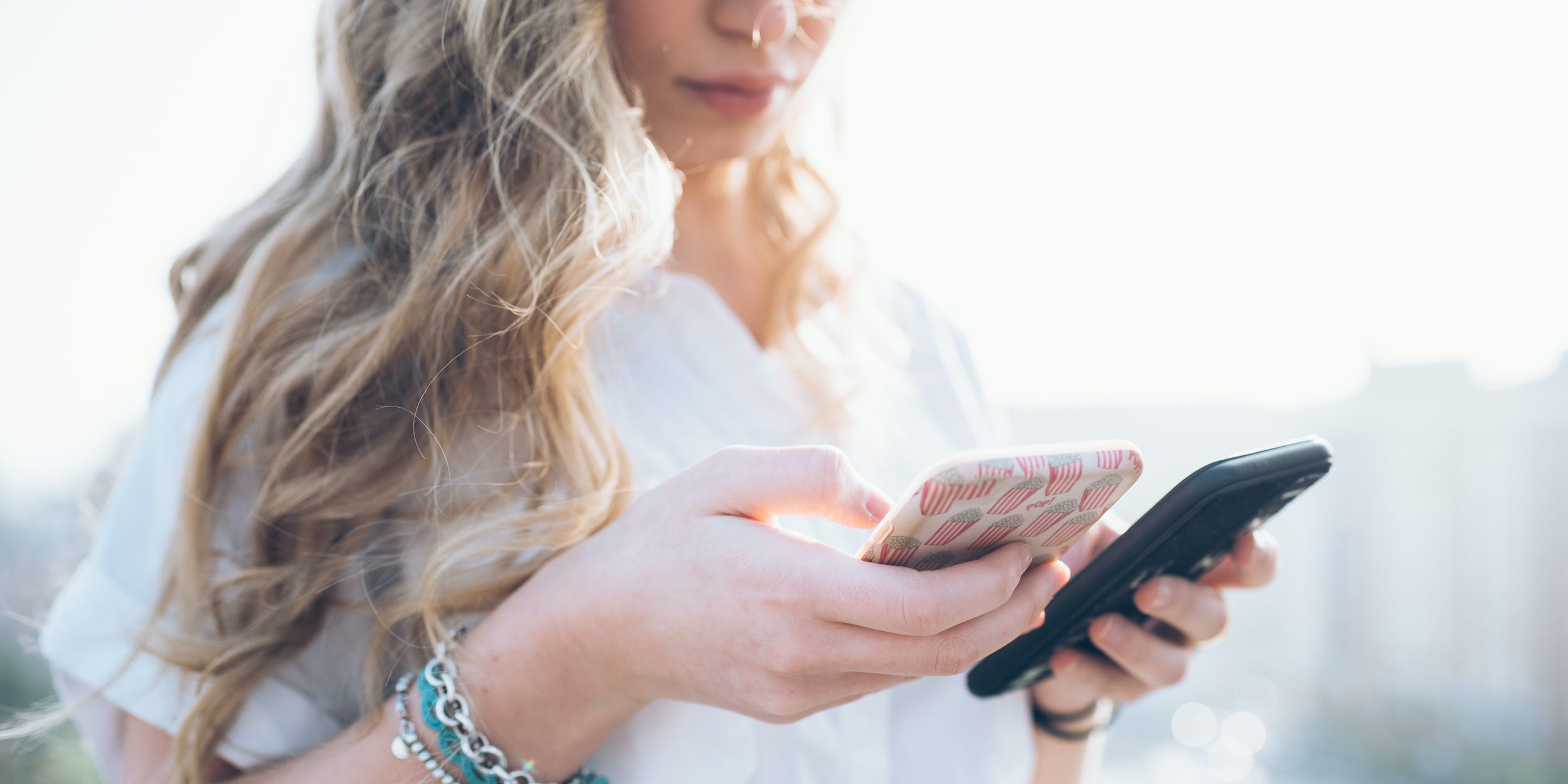 Woman holding two smartphones in hand