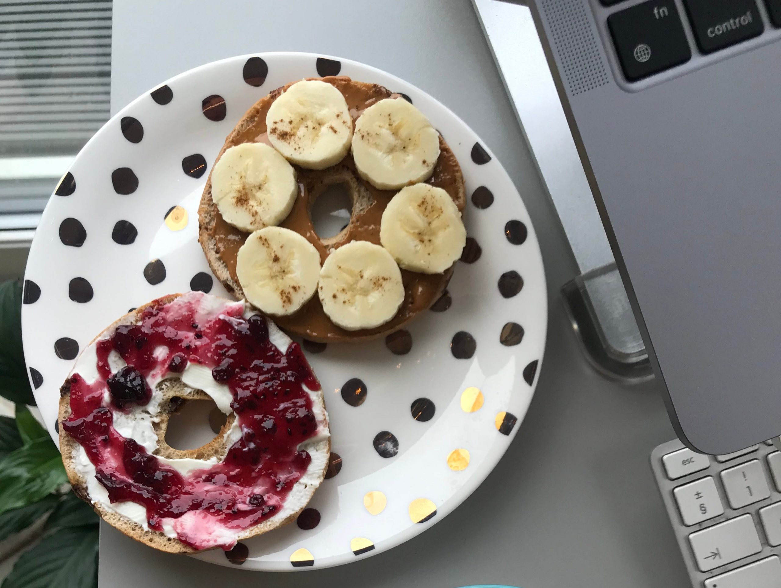 A bagel with yogurt on the side.