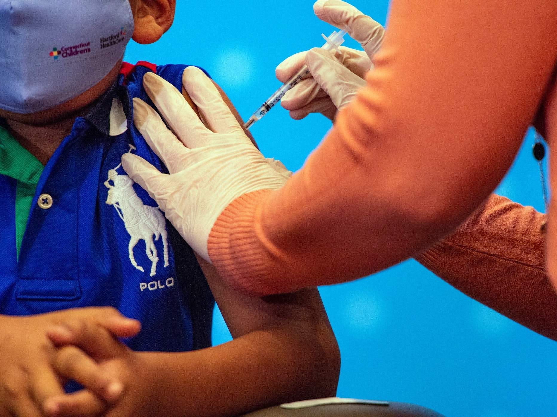 a chlid's arm getting injected with pfizer's covid-19 vaccine