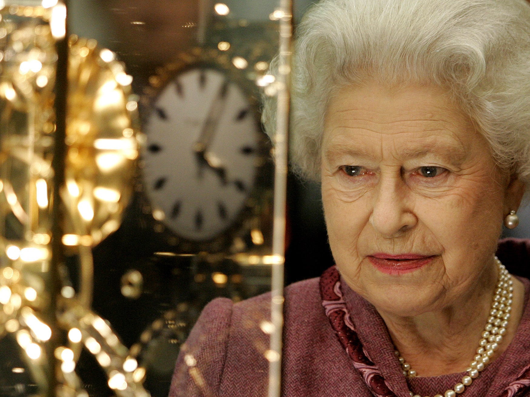 Queen Elizabeth ll looks at a gift of a replica of the St. Pancras Station clock as she officially opens St. Pancras International Station, the new home to Eurostar, on November 7, 2007 in London, England.