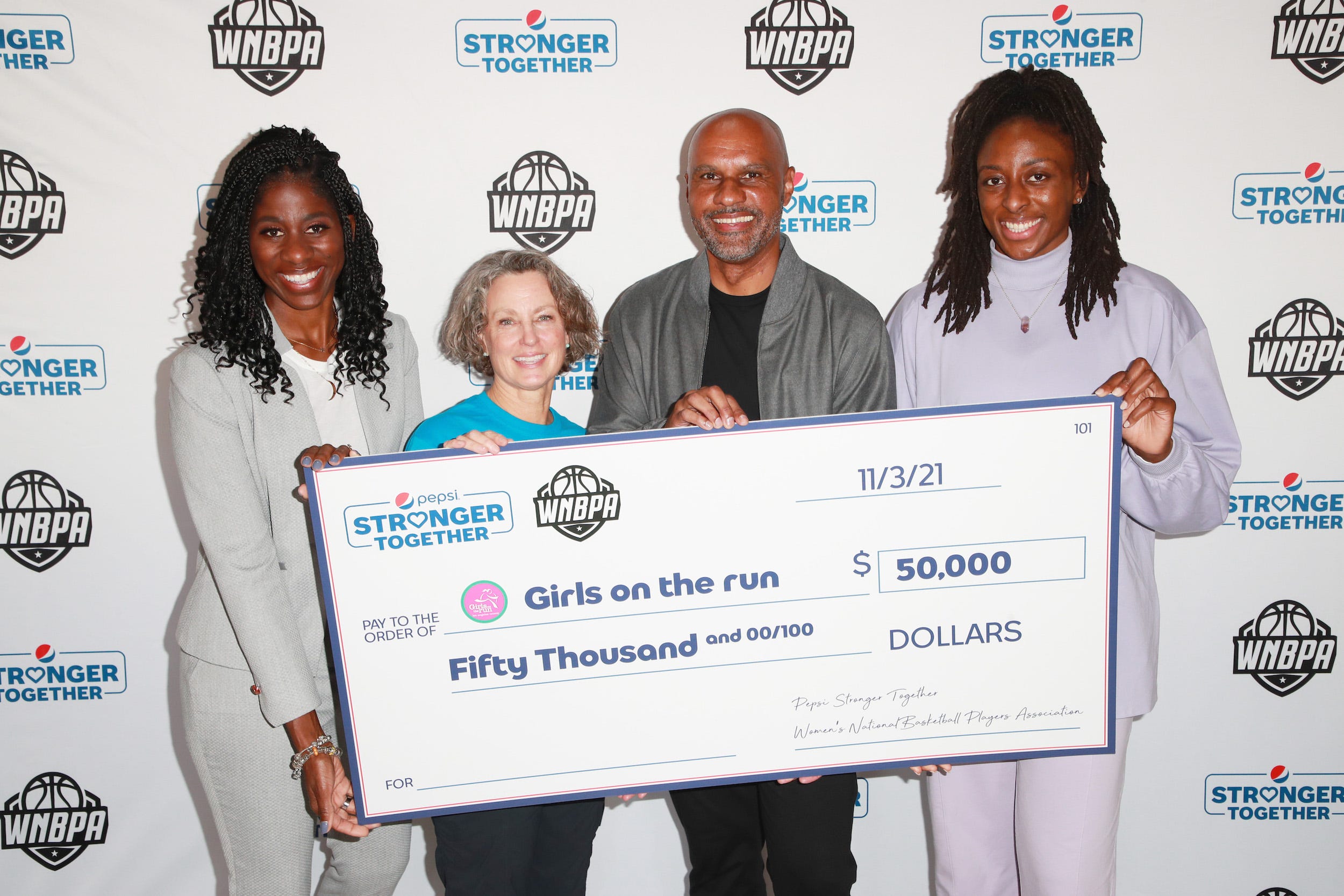 From left: Terri Carmichael Jackson, Molly Snow, Derek Lewis, and Nneka Ogwumike pose with a ceremonial check for Girls on the Run LA during the Pepsi Stronger Together-WNBPA partnership announcement.