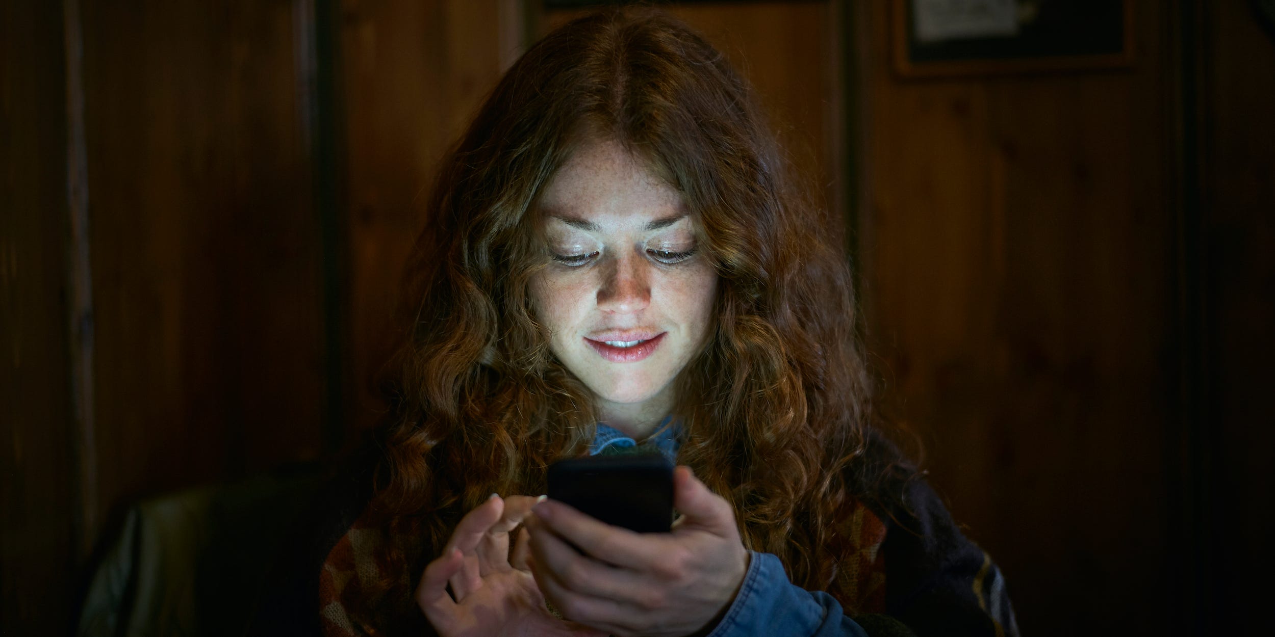 woman looking at smartphone in darkness