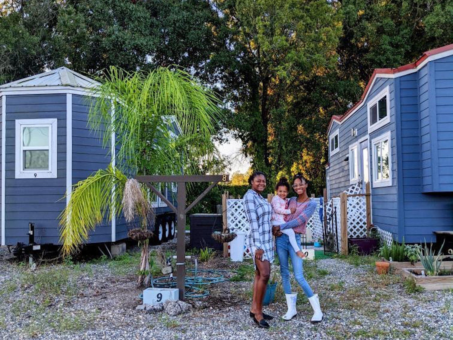 Ashley and Alexis Okegbenro Monkhouse standing outside their tiny homes in Tampa, Florida.