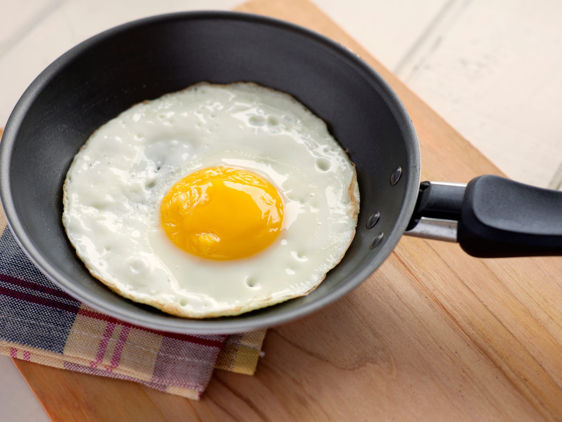 A sunny-side-up egg in a frying pan.