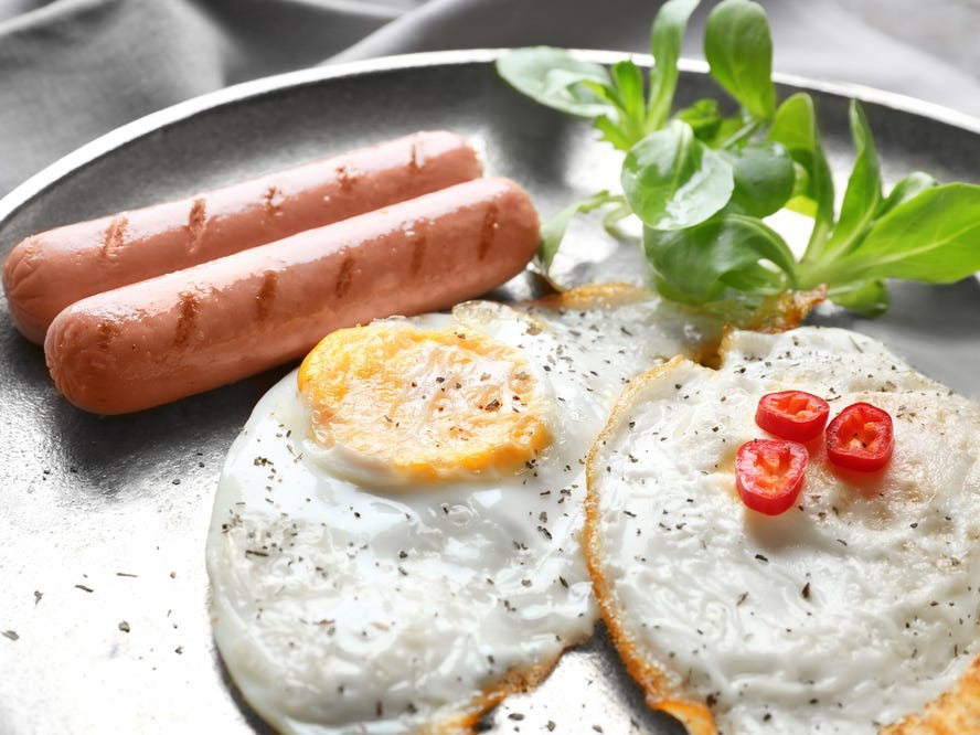 Over-hard eggs on a plate with other breakfast foods.