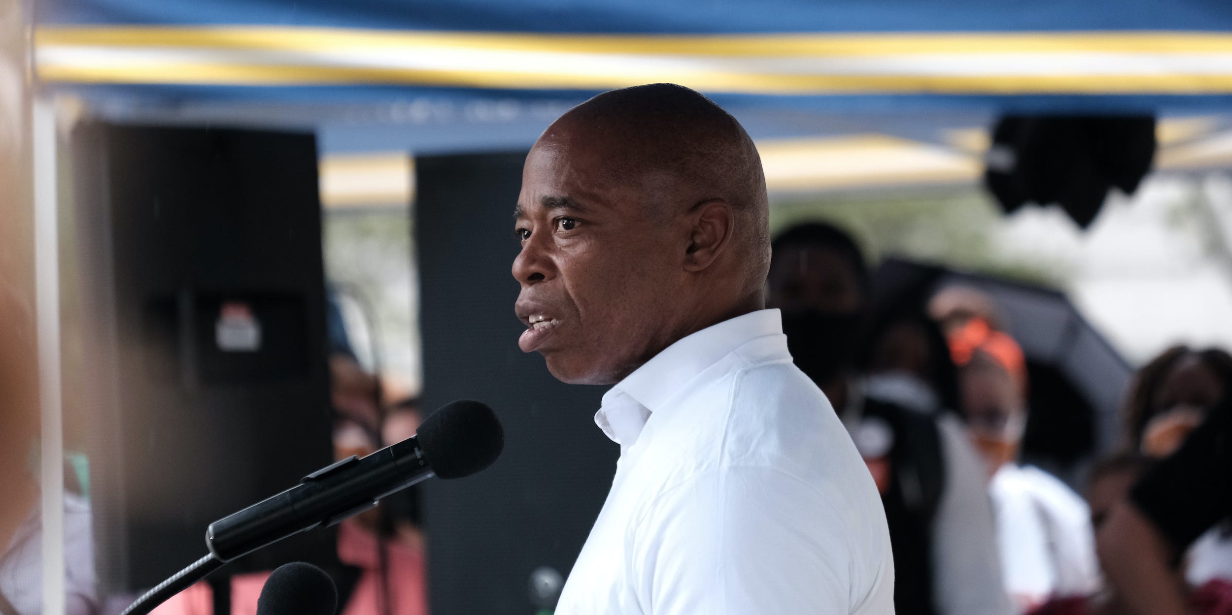 New York City Democratic mayoral nominee Eric Adams speaks in profile at a microphone.