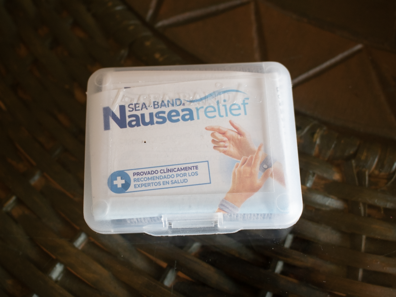 A white pack of sea-nausea relief banks on brown table